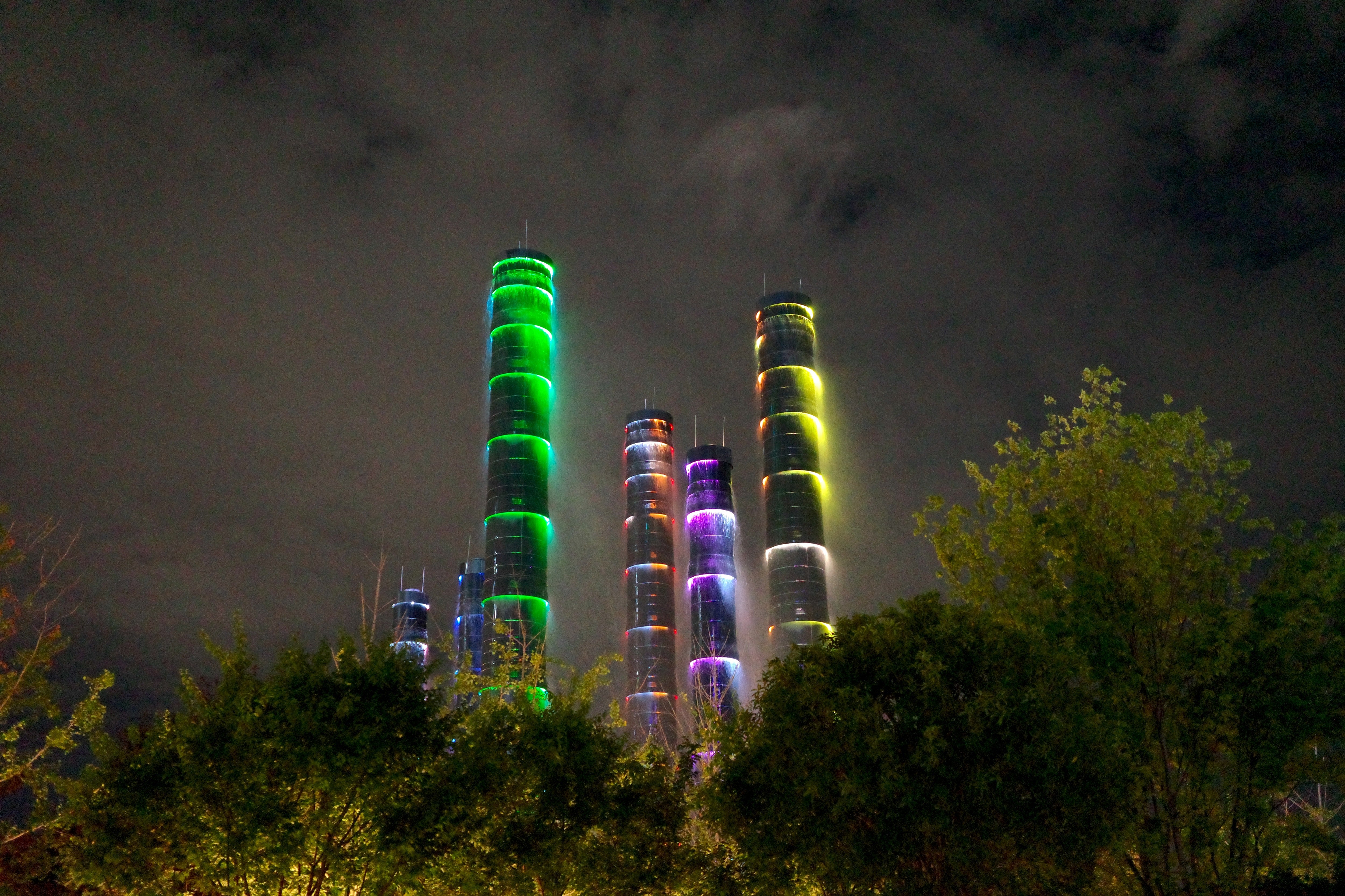 The Tower of Life installation consists of several bamboo-shaped pillars glowing in a succession of neon-lit rainbow colours