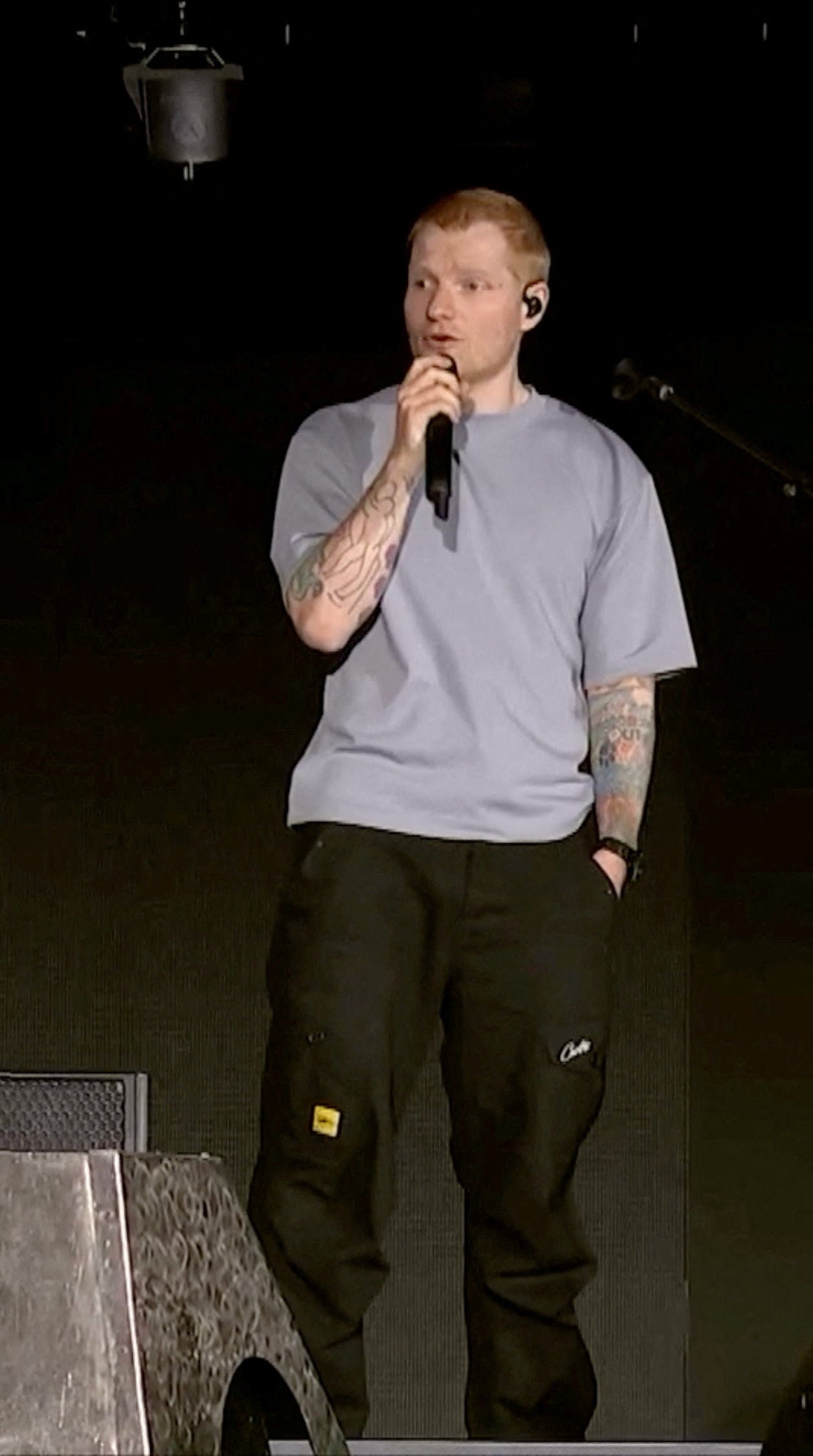 Singer Ed Sheeran speaks on stage as he addresses a controversy over Macklemore being pulled from the tour after saying 