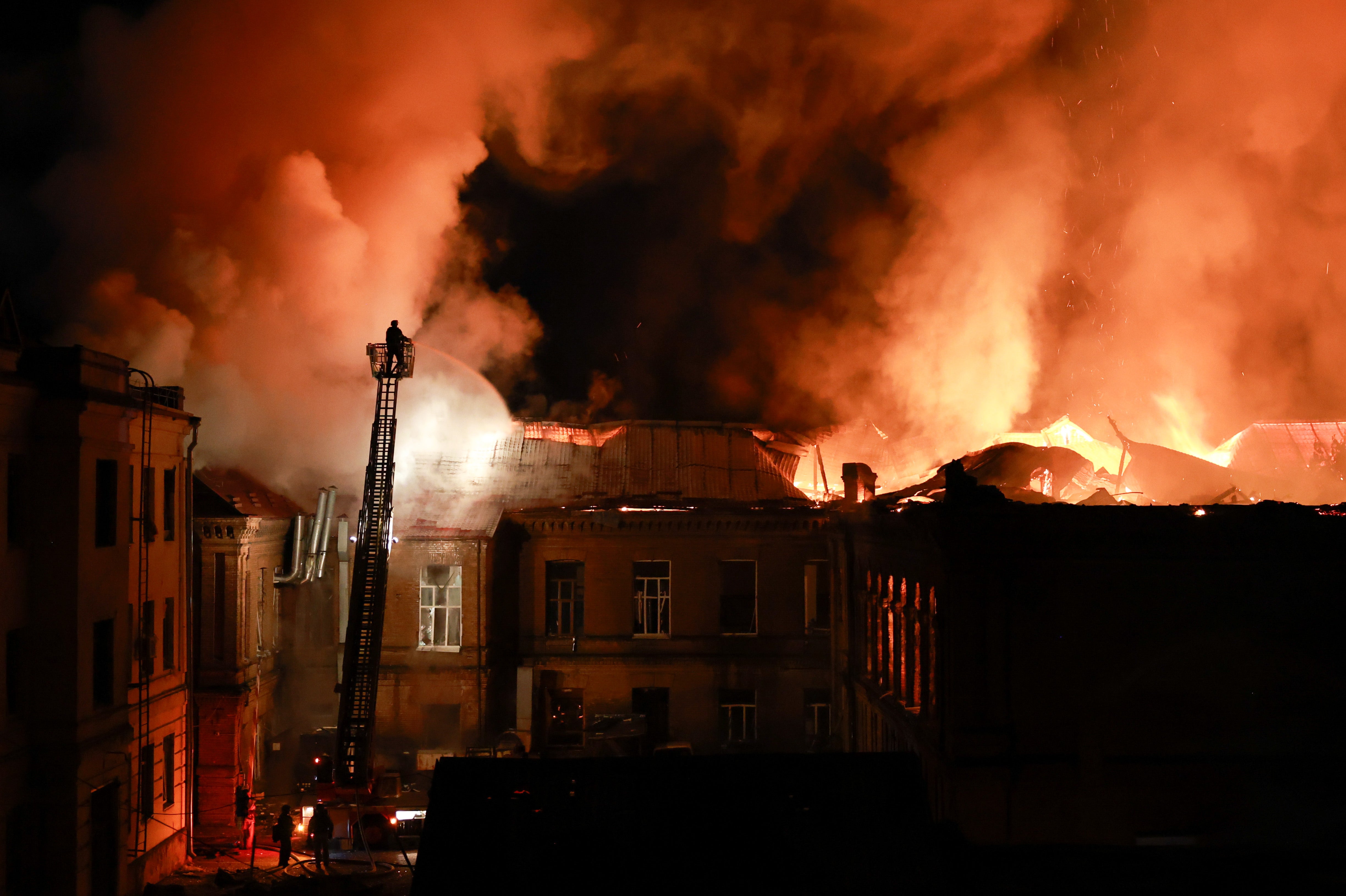 A rescue worker puts out a fire at the 120-year-old historic building of Zaporizhzhia National University (AP)