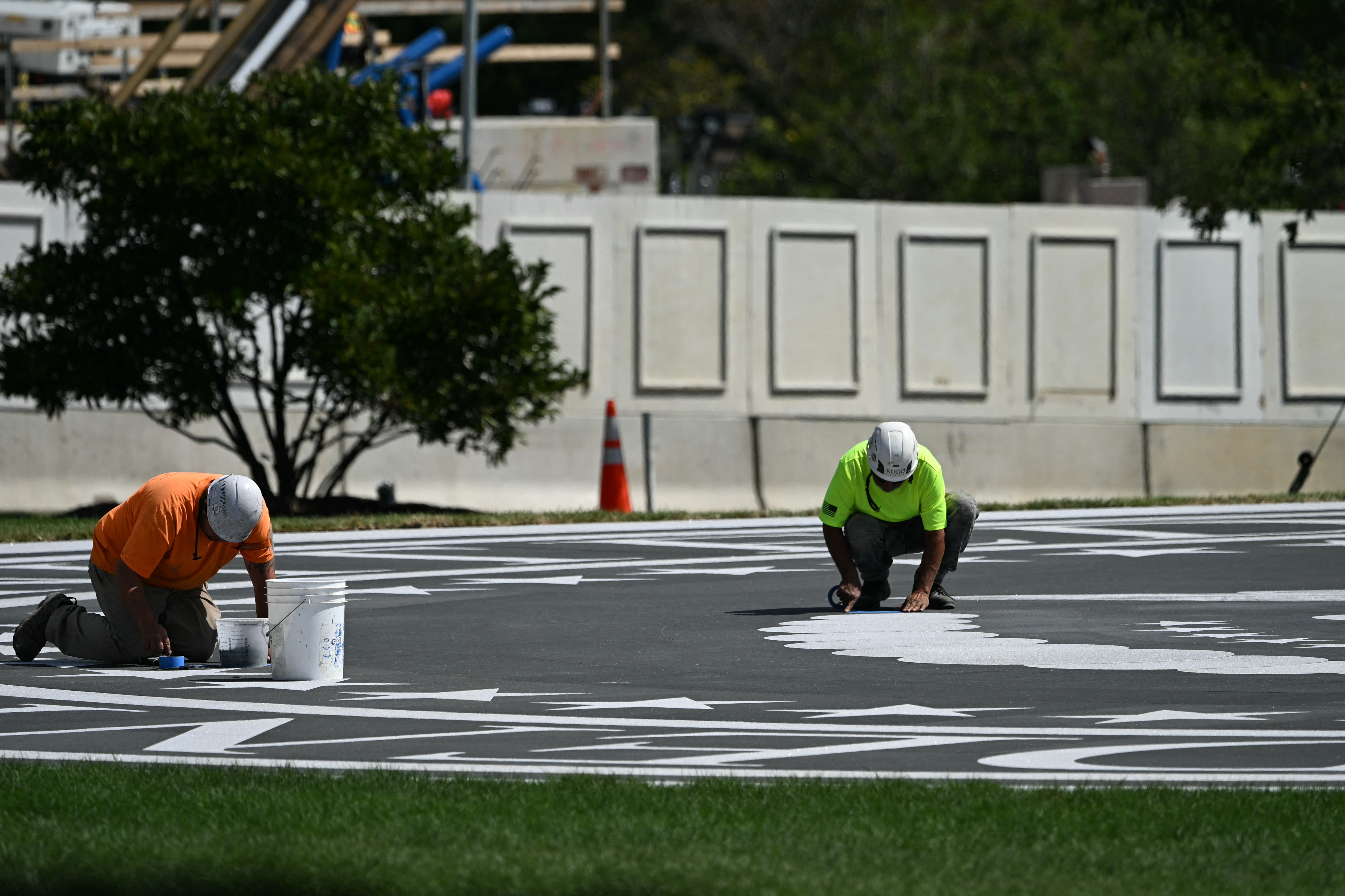 Workers rush to finish the White House helipad ahead of Xi's arrival in the nation's capital