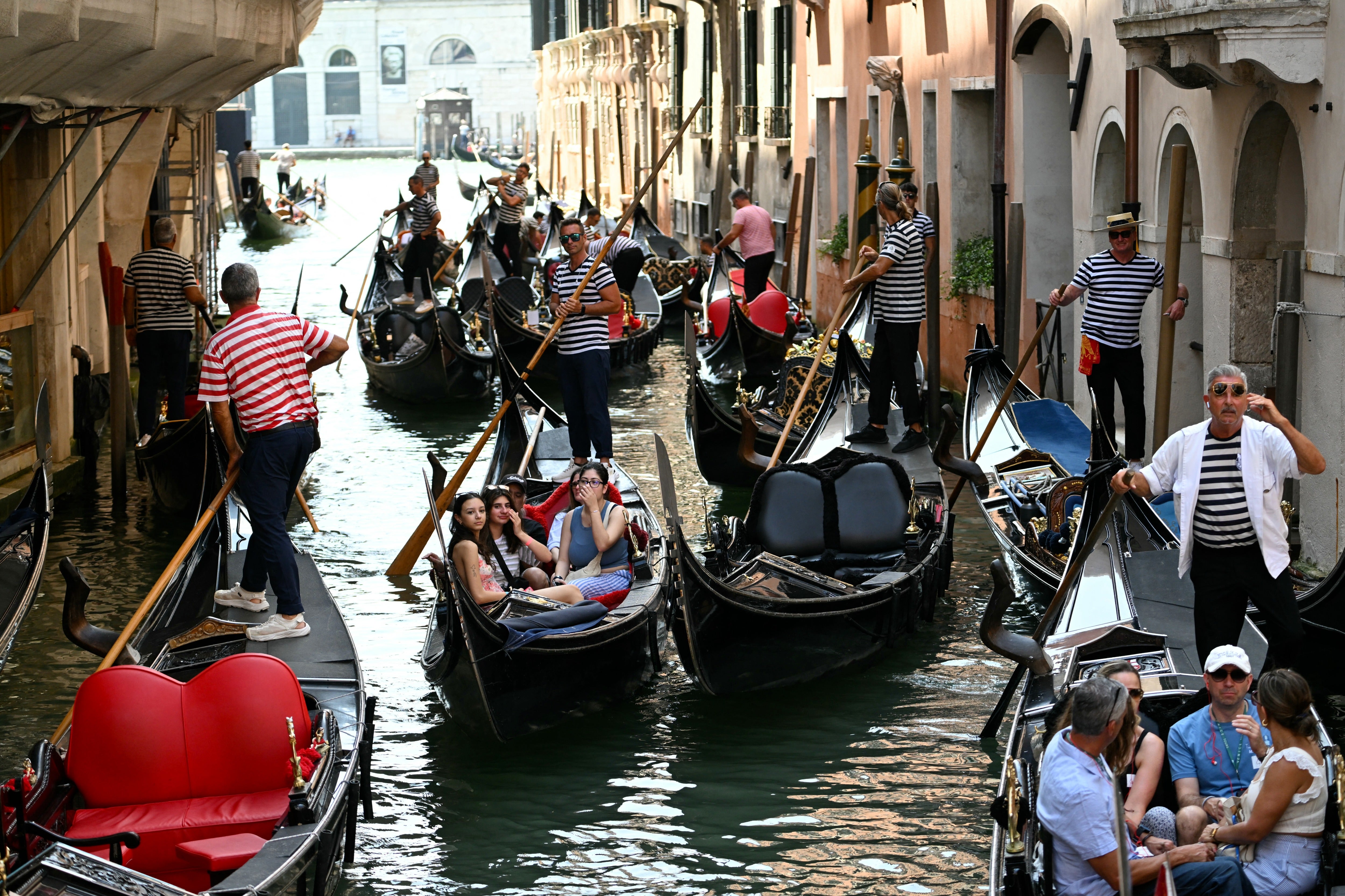 Tourists on a gondola ride in Venice lagoon, on June 24, 2025