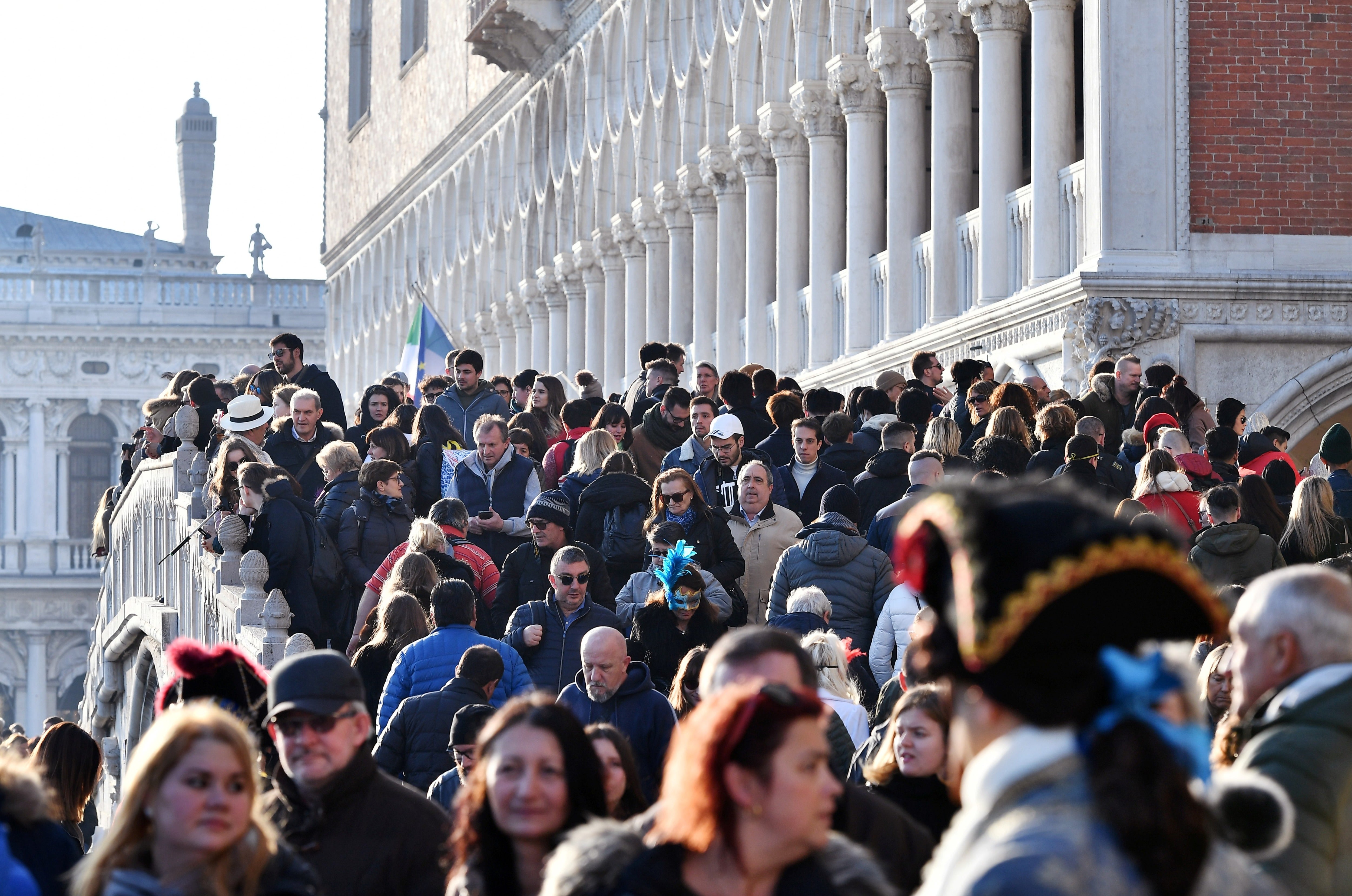 Tourists walk across the Bridge of Sighs on the Riva degli Schiavoni in Venice, northeastern Italy, on Feb. 16, 2019