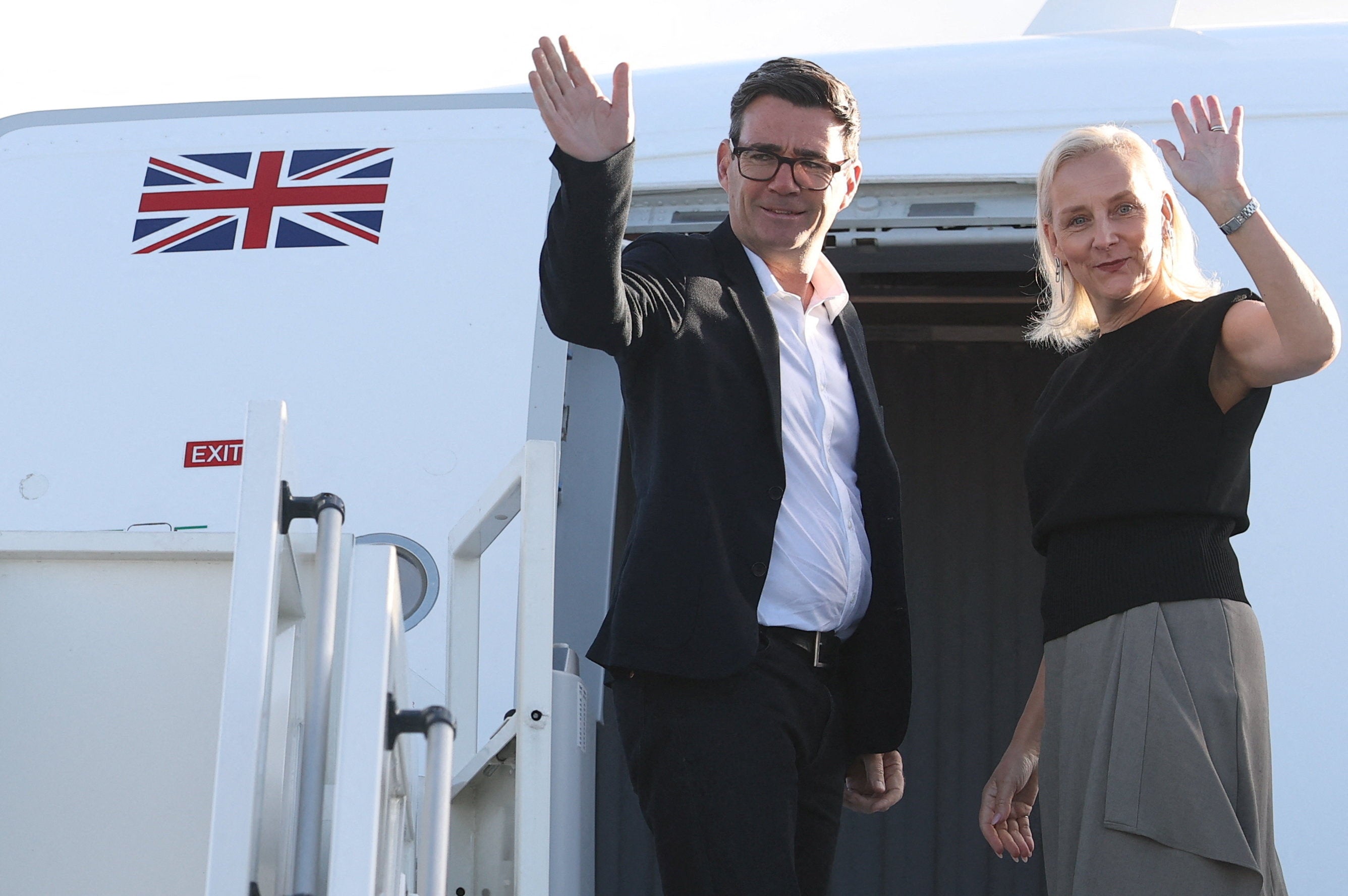 Andy Burnham and his wife Marie-France van Heel board a plane at Stansted Airport