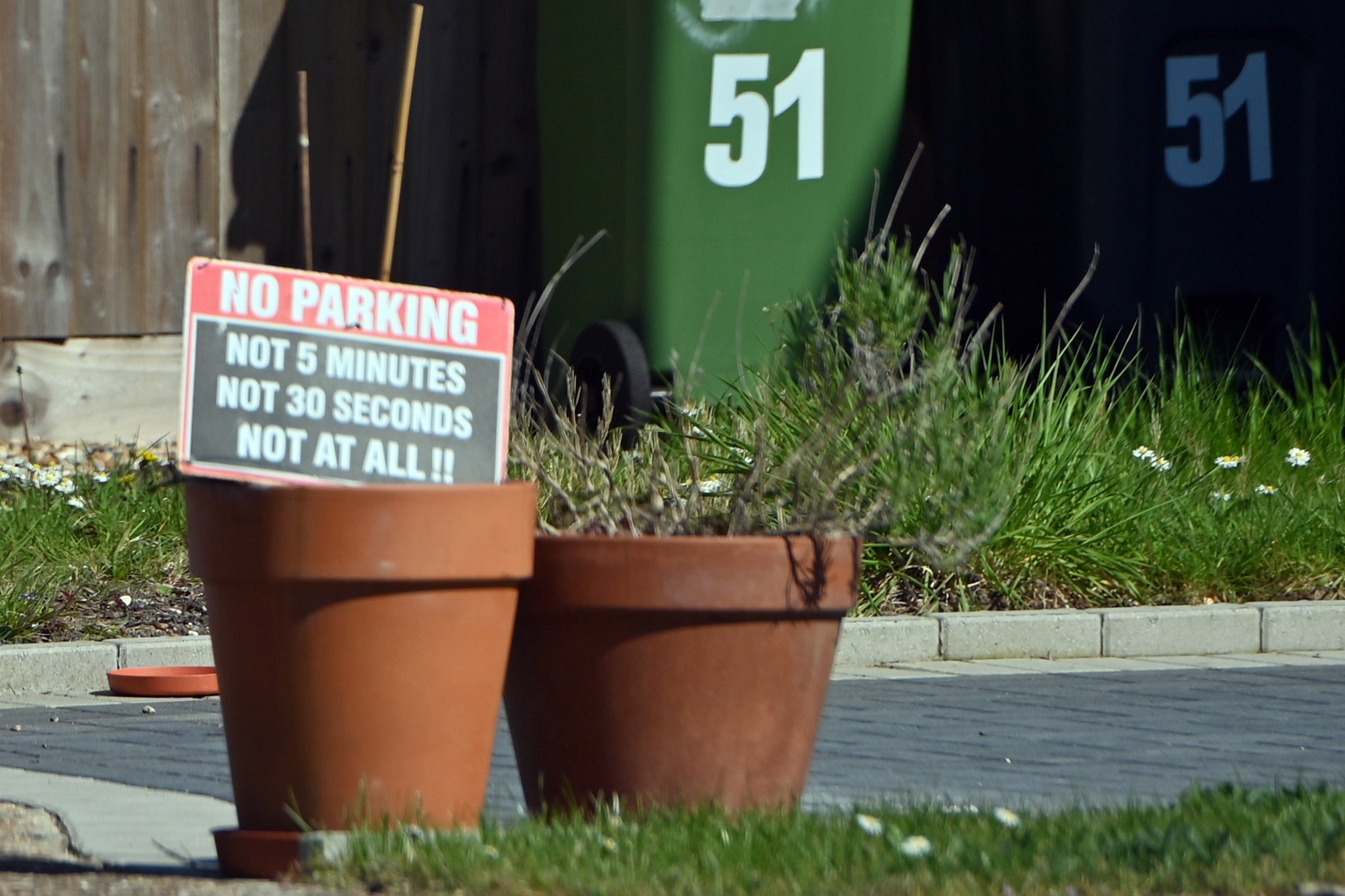 Signs placed in plant pots outside Sally Beaney's home and driveway