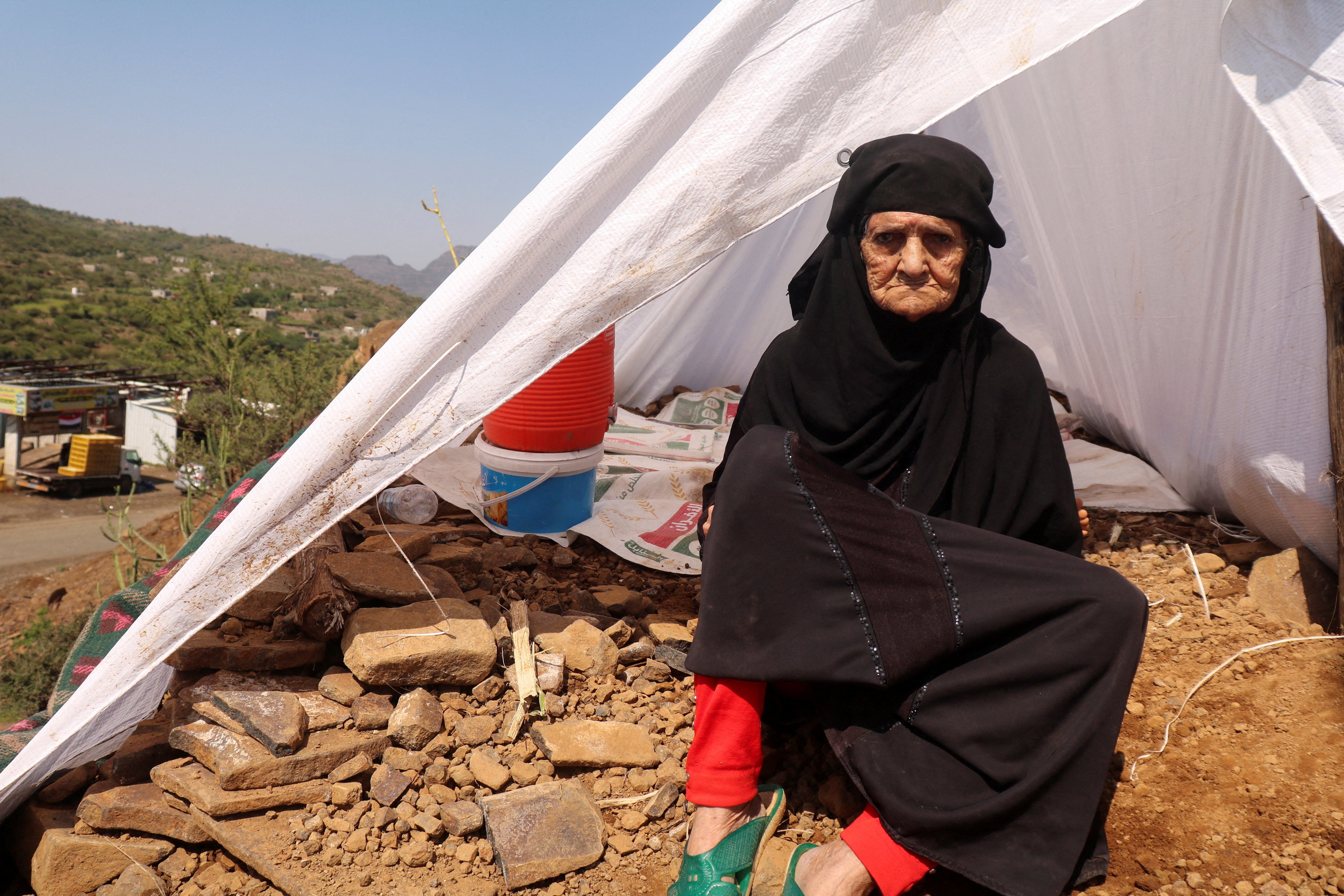 A displaced woman sits outside her tent at a makeshift camp for people displaced by clashes between Iran-aligned Houthi fighters and Saudi-backed Yemeni government forces, in Taiz province, Yemen (Reuters)