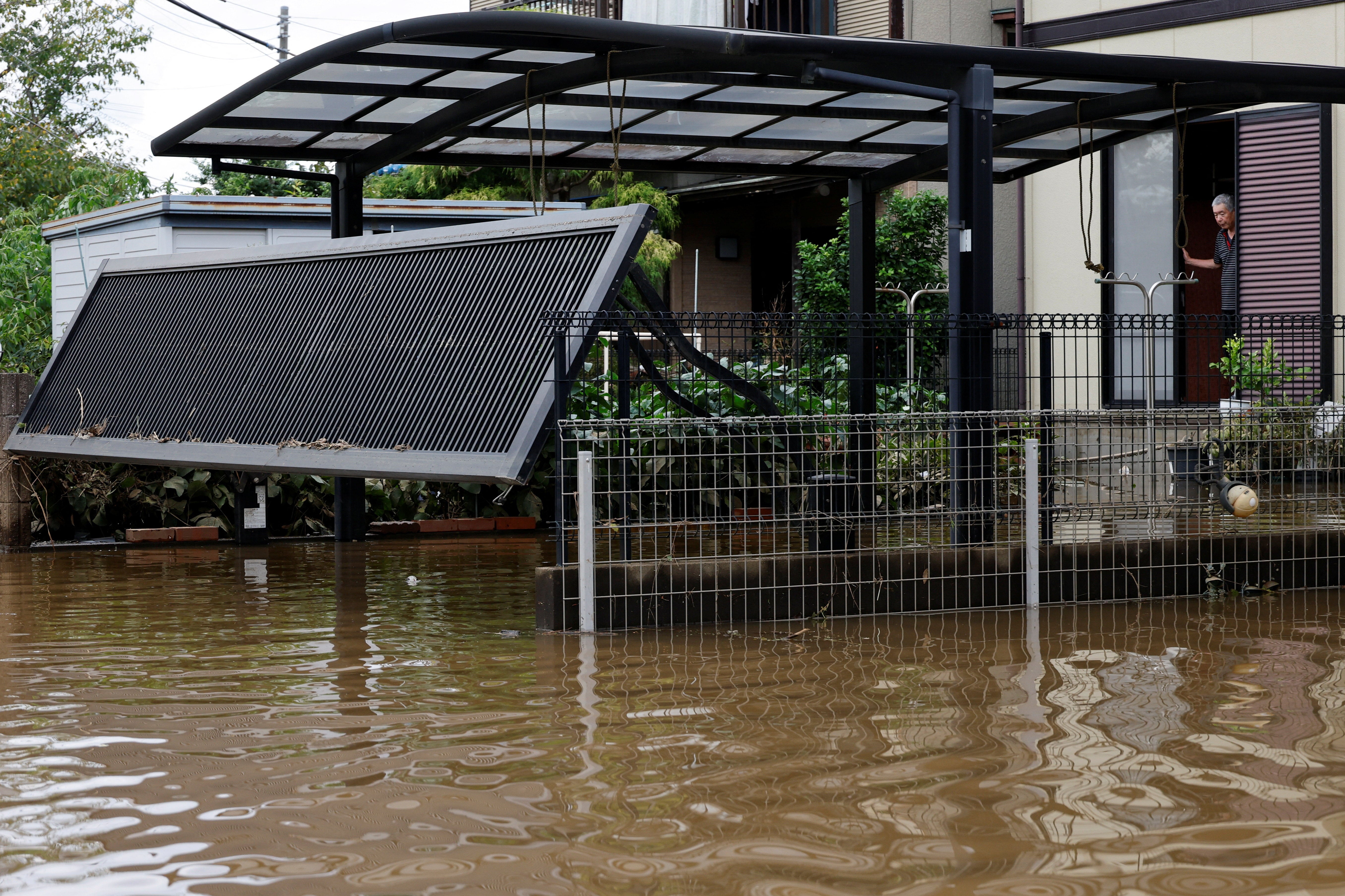 A resident looks out at floodwaters after Typhoon Dujuan brought torrential rain to Sakura, Chiba prefecture, Japan, 22 September 2026 (Reuters)