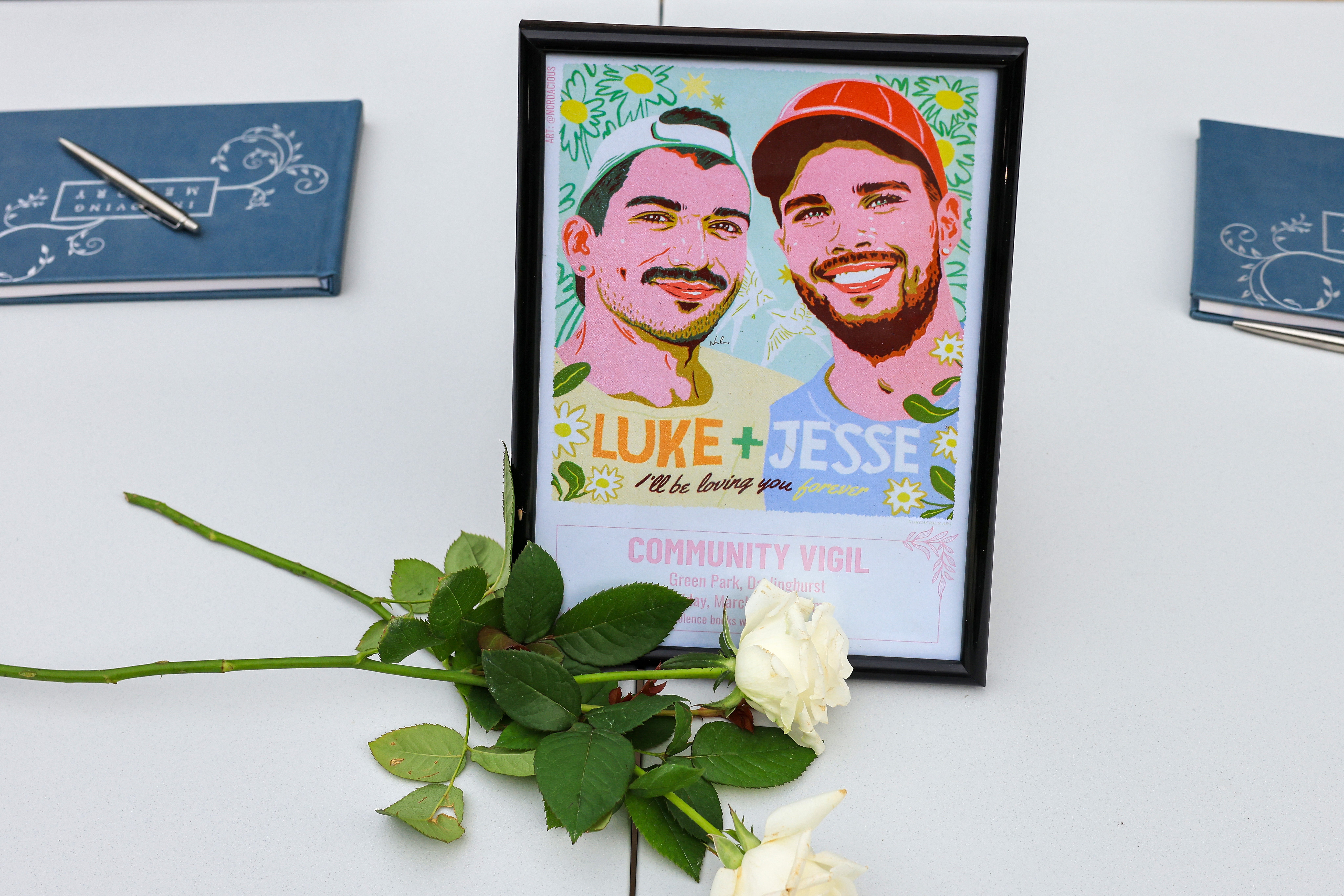 Condolence books and a poster in honour of Jesse Baird and Luke Davies seen during a public vigil at Green Park on 1 March 2024 in Sydney (Getty)