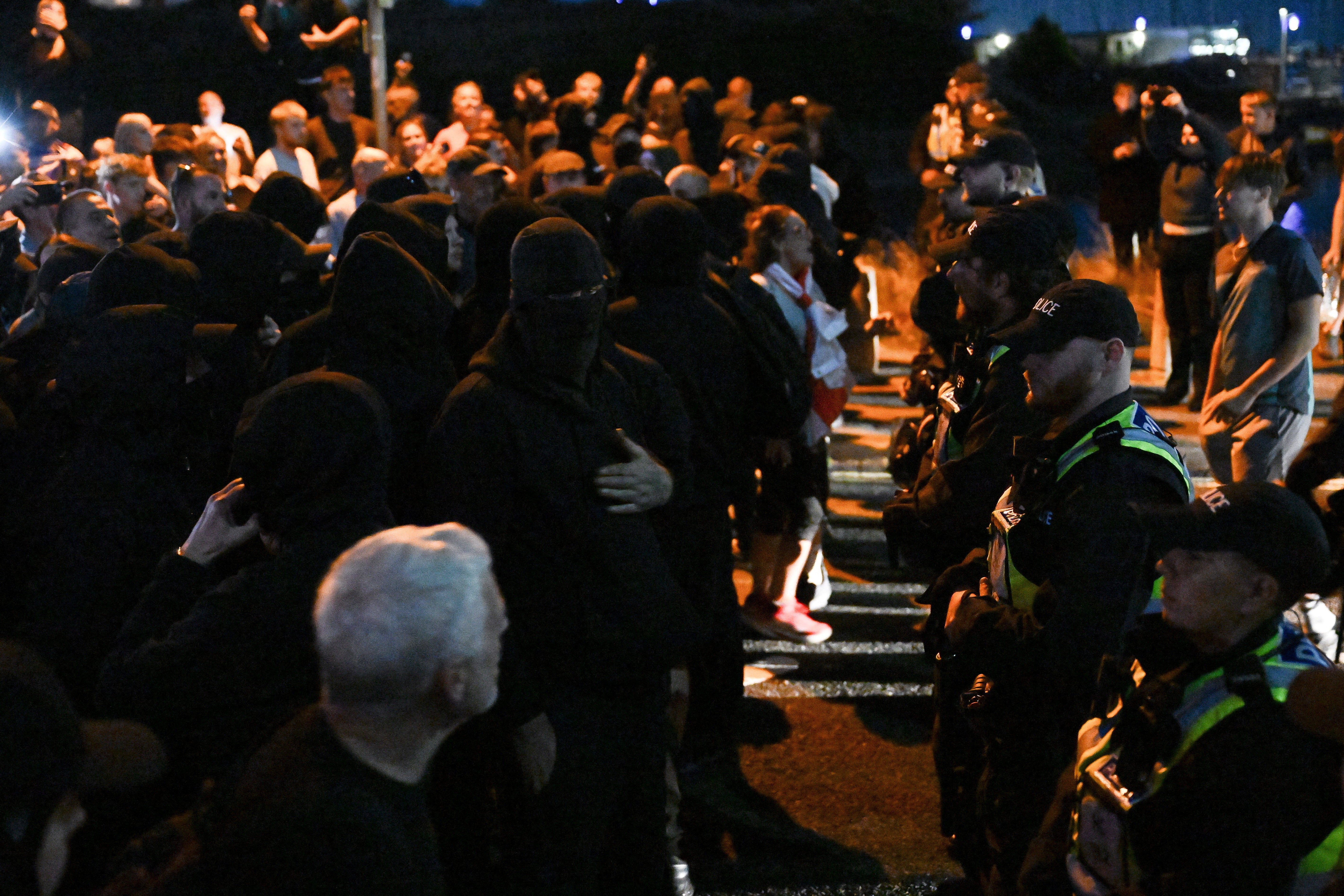 A number of men wearing black, several with face coverings, were at the front of the protest