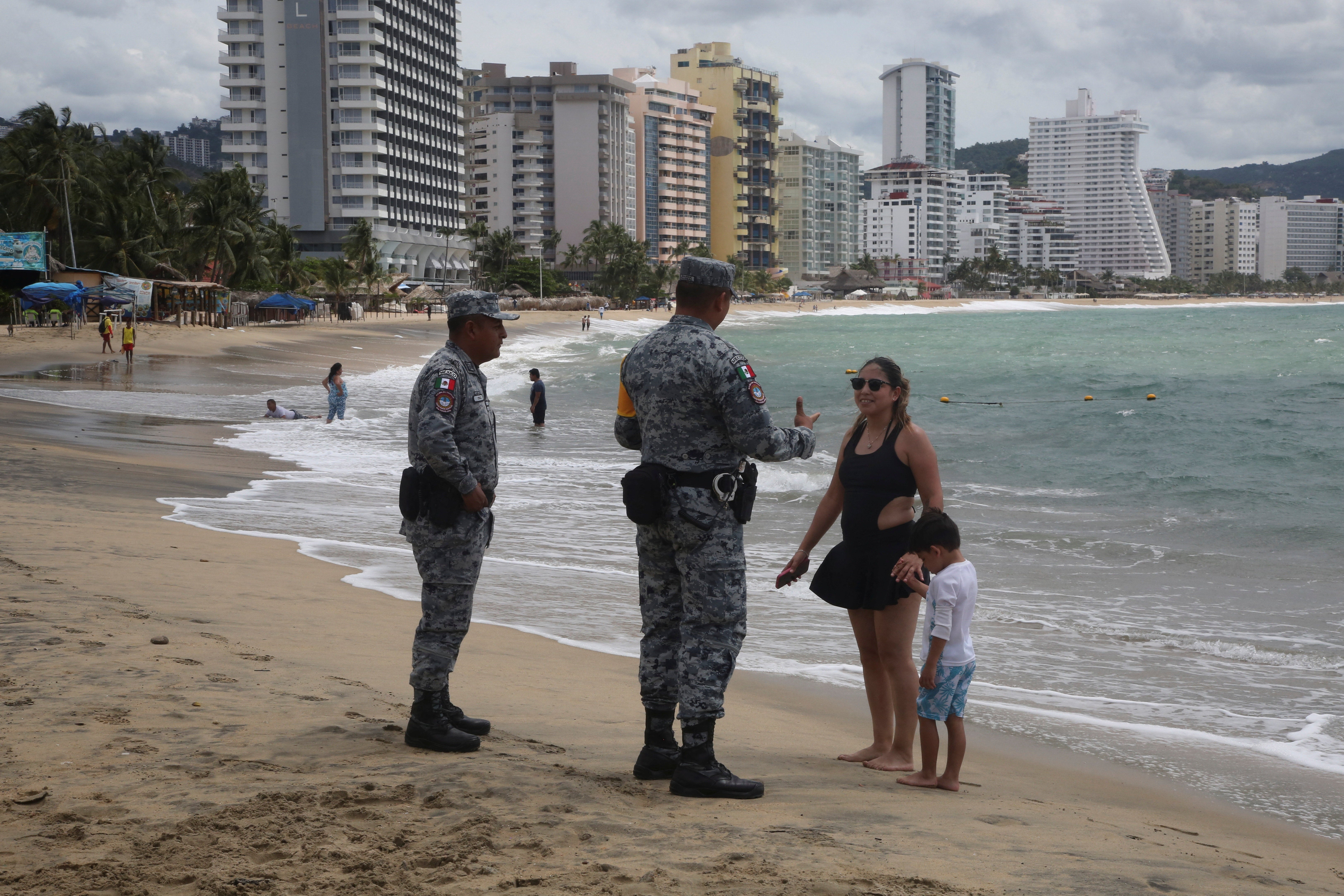 A tourist receives safety recommendations from a member of the National Guard on a beach as Category 4 Hurricane Polo strengthens off Mexico's Pacific coast. (Reuters)