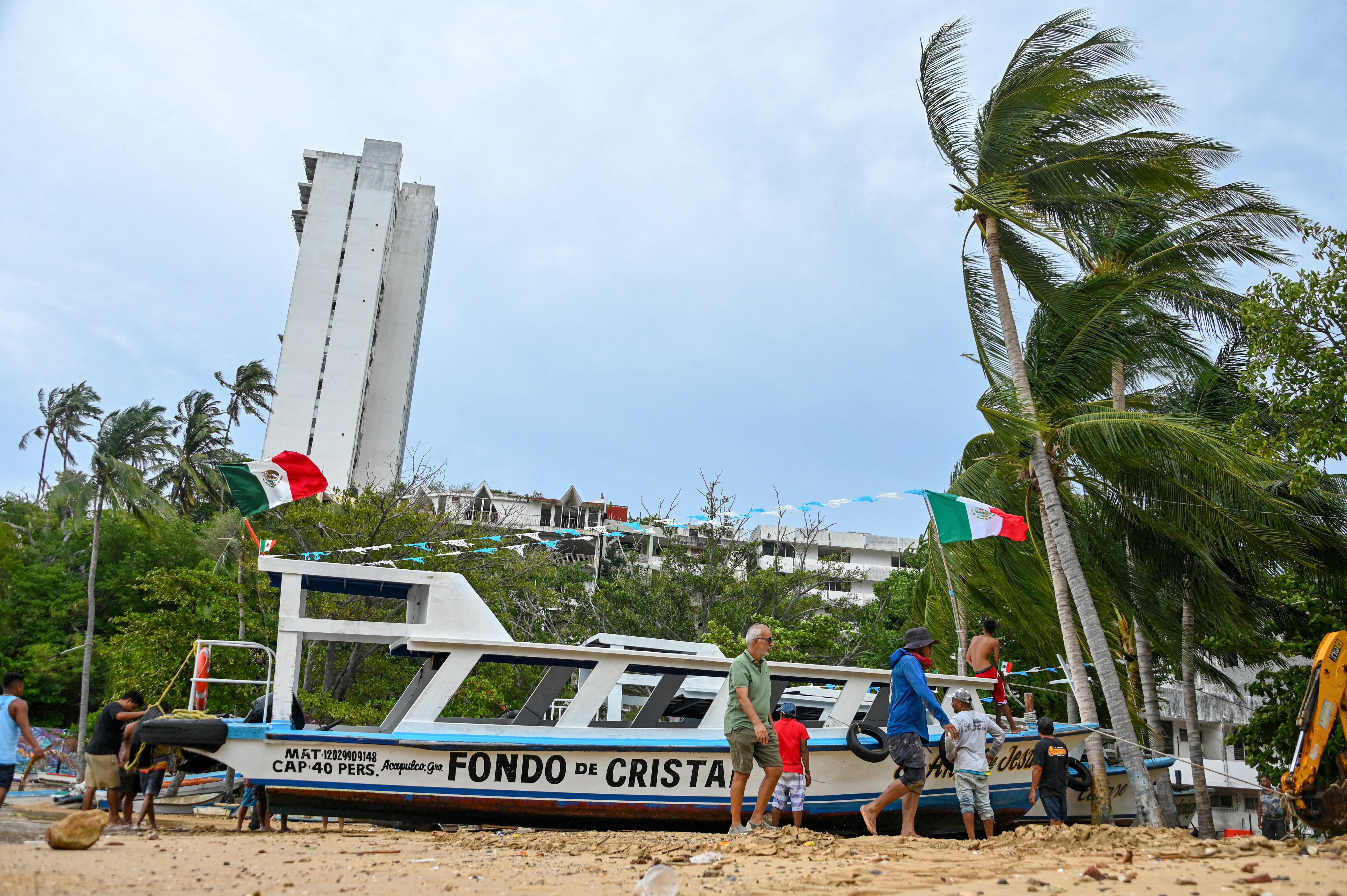 Sailors and fishermen secure a passenger boat on the beach as Hurricane Polo approaches Acapulco, Guerrero state, Mexico. (AFP/Getty)