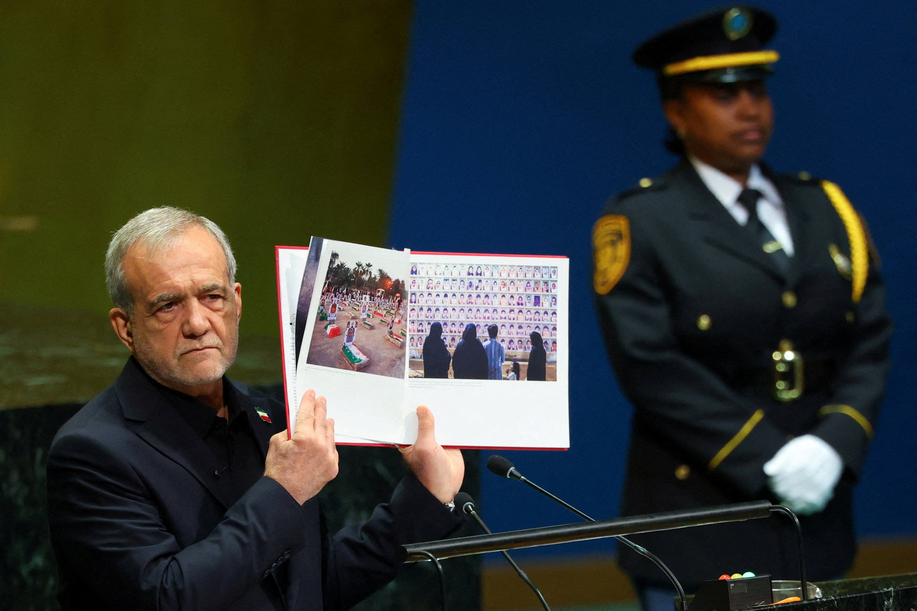 Iran's President Masoud Pezeshkian shows pictures of the Iranian school hit in a suspected US strike