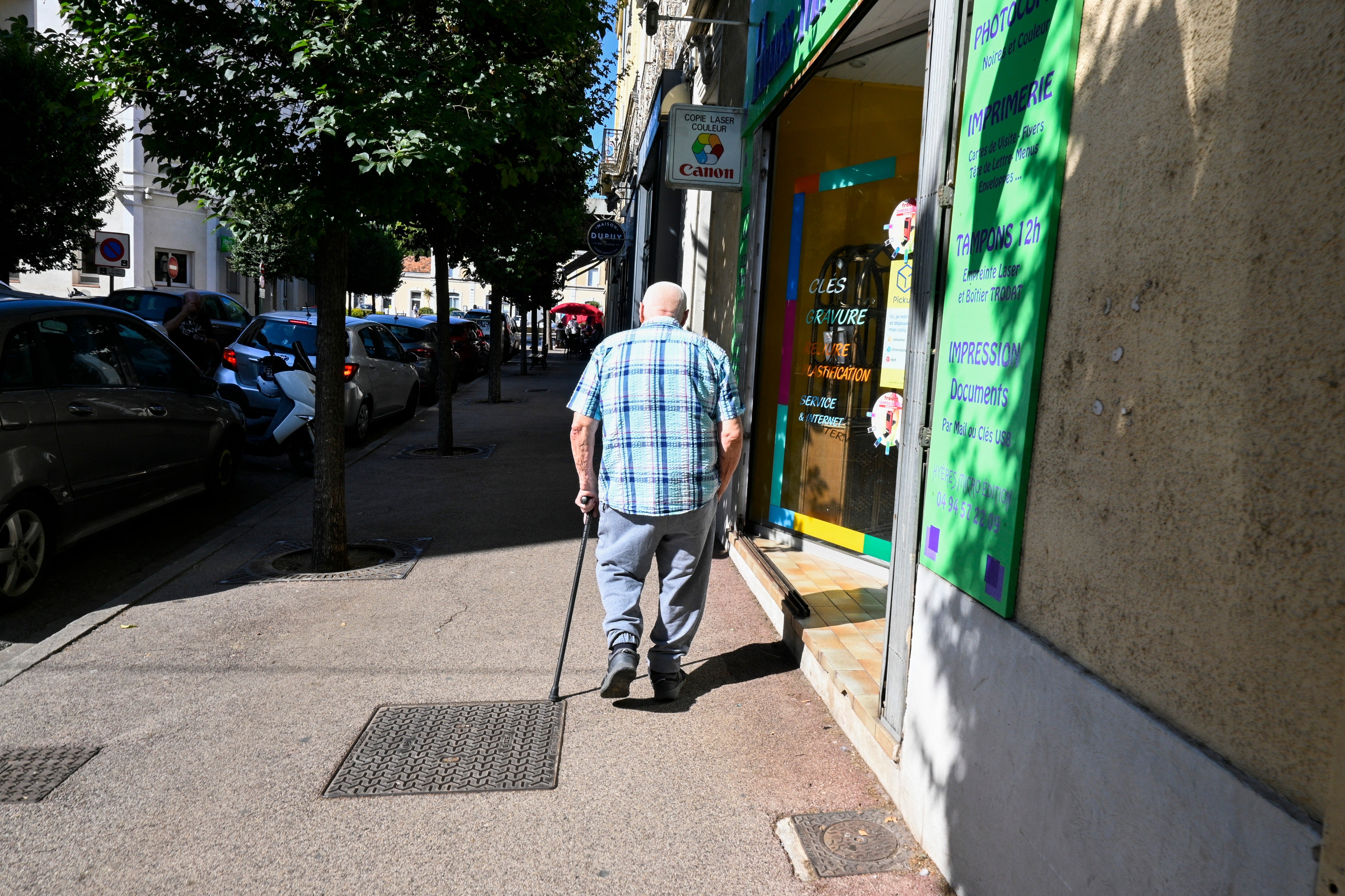 An old man, senior citizen, walking with his walking stick in the heat of a heatwave