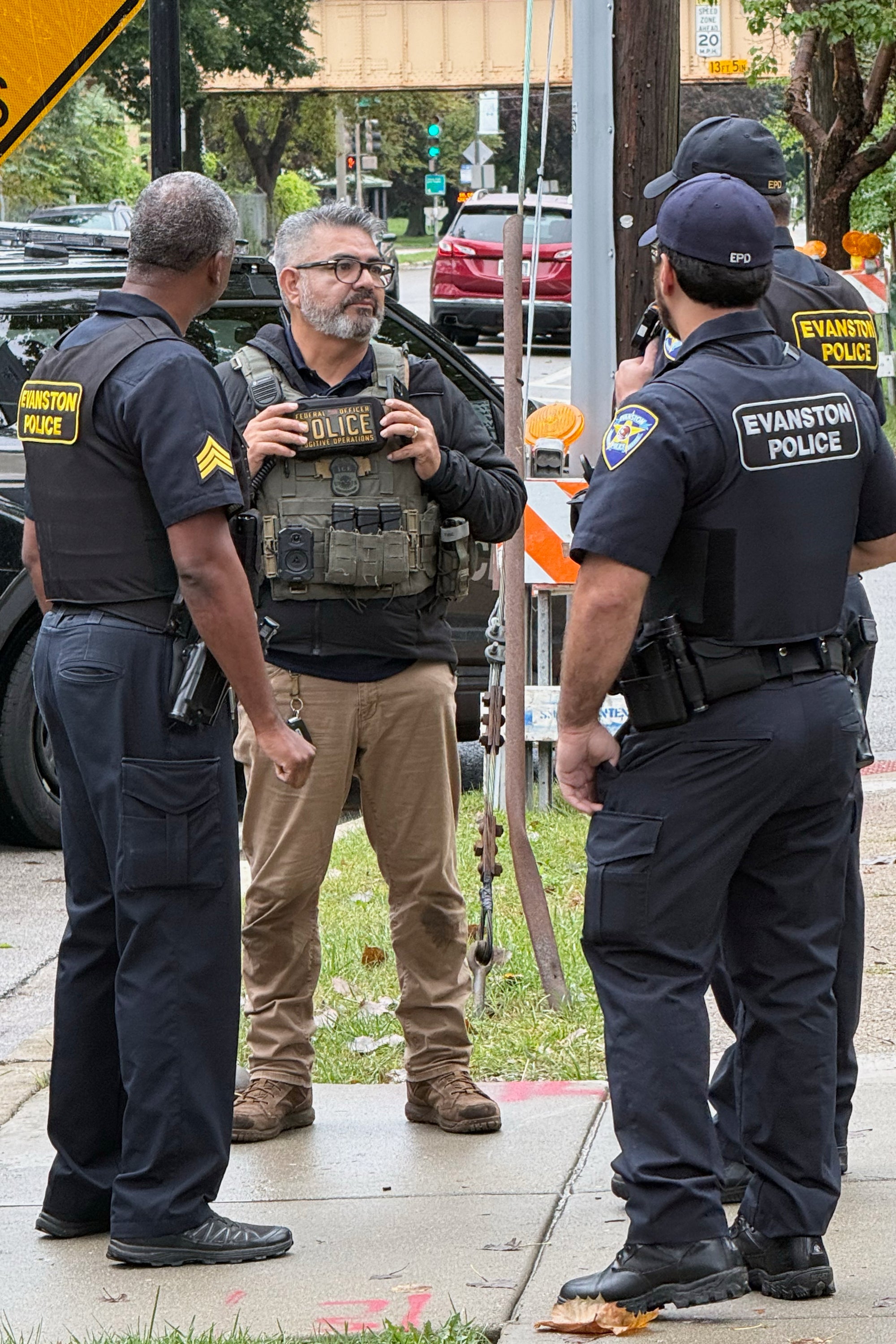 This photo taken with a smartphone and provided by Ryan Garton shows a federal officer speaking to Evanston, Ill., police officers