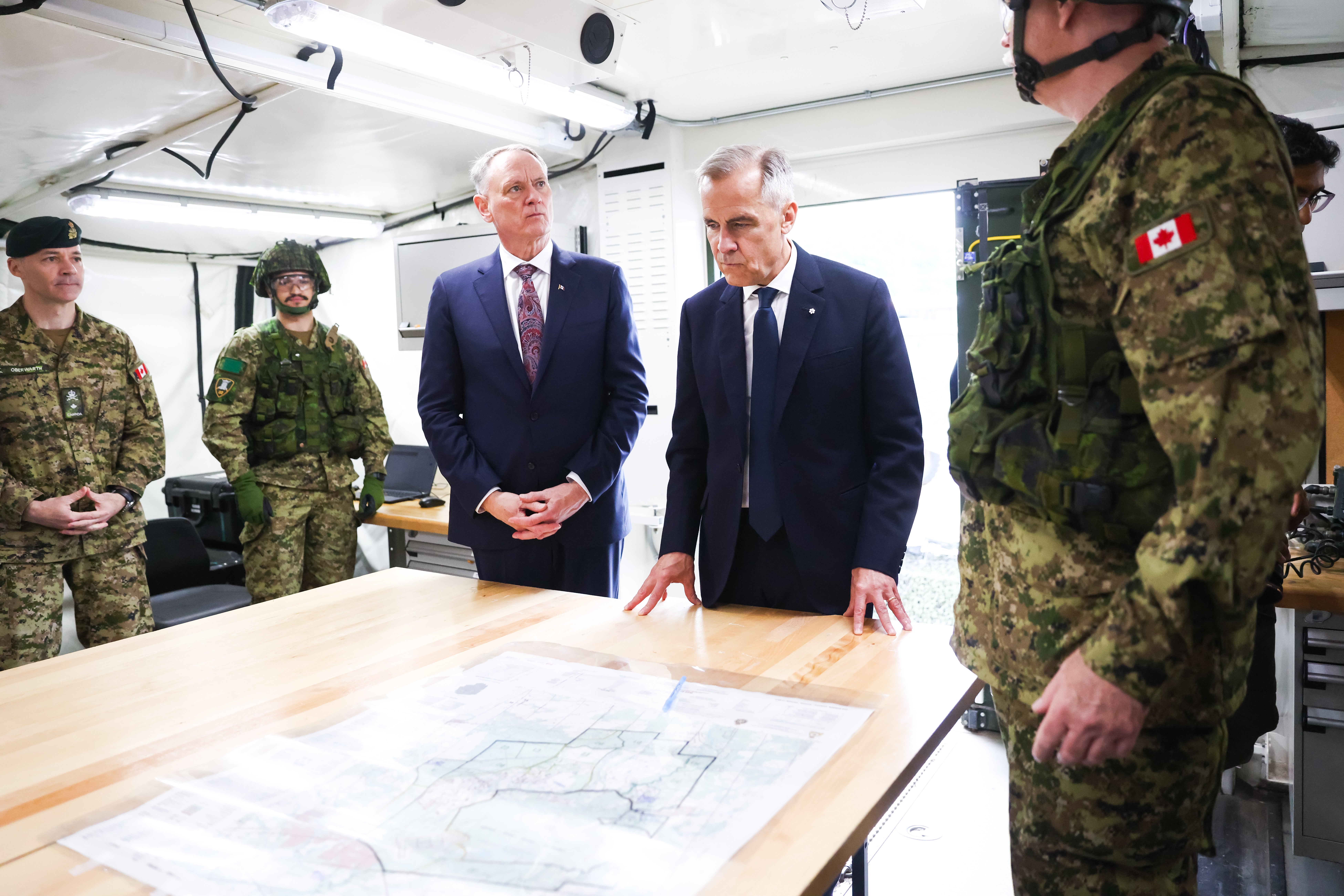 Mark Carney, right, and Minister of National Defence David McGuinty meet with troops of the 4th Canadian Division on a tour of the Fort York Armoury in Toronto in June