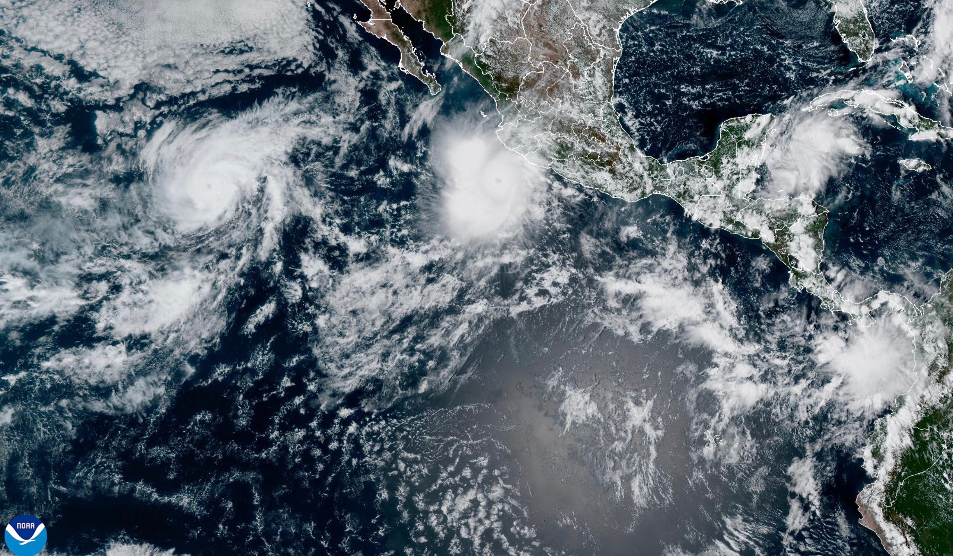 This satellite image provided by NOAA shows Hurricane Polo off the southwestern coast of Mexico and Hurricane Odalys, left, on Thursday, Sept. 24