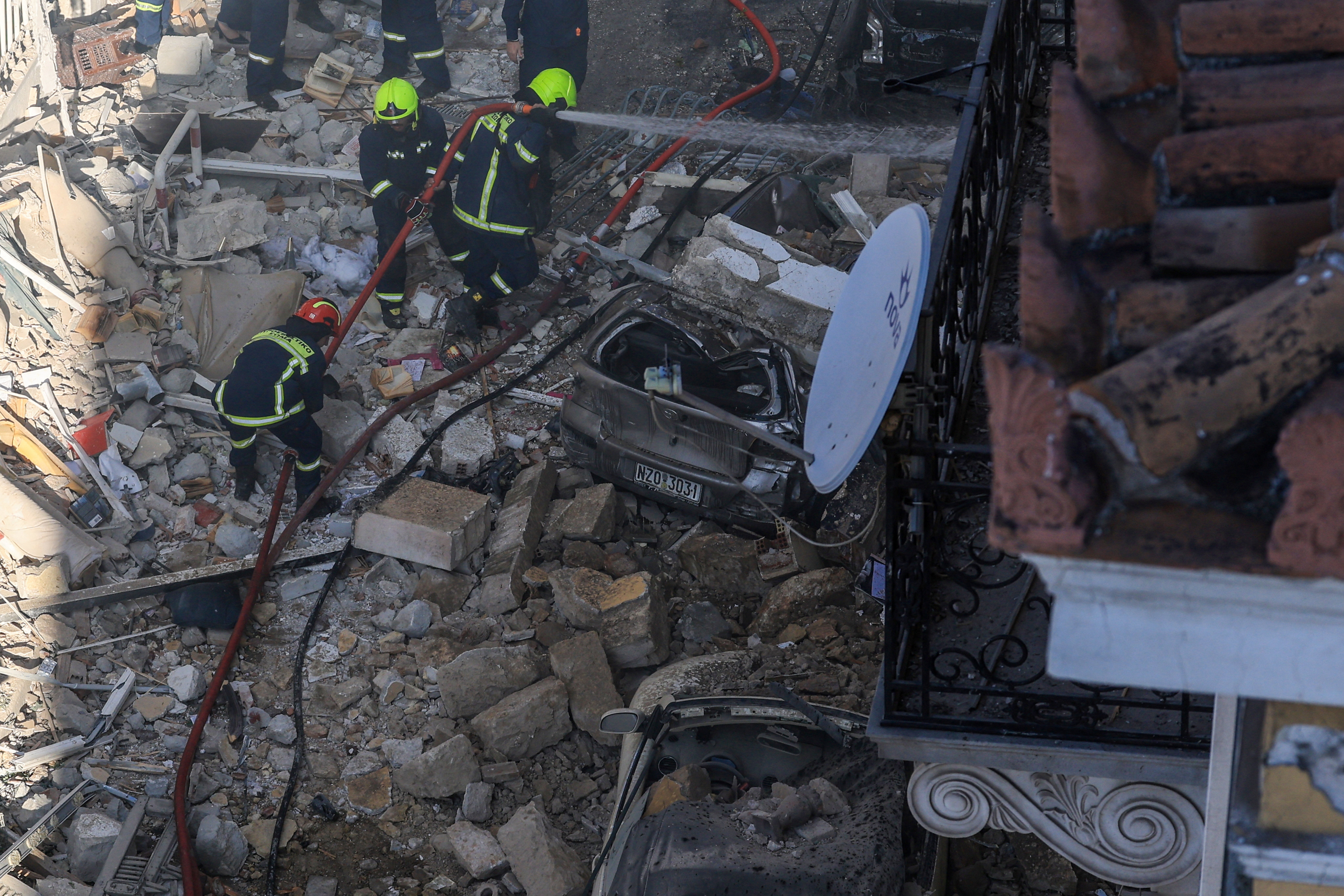 Emergency personnel work at the site where an old building partially collapsed in Athens on Friday