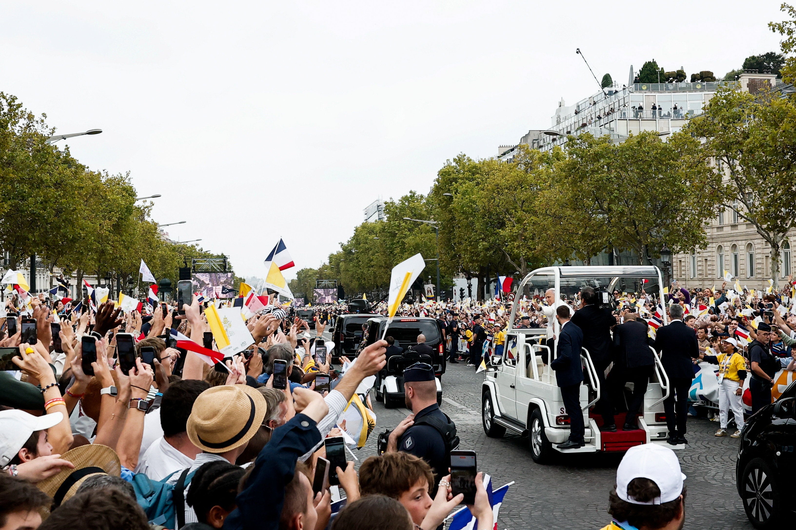 People react as Pope Leo travels in the popemobile on the Champs-Elysees avenue near the Arc de Triomphe (Reuters)