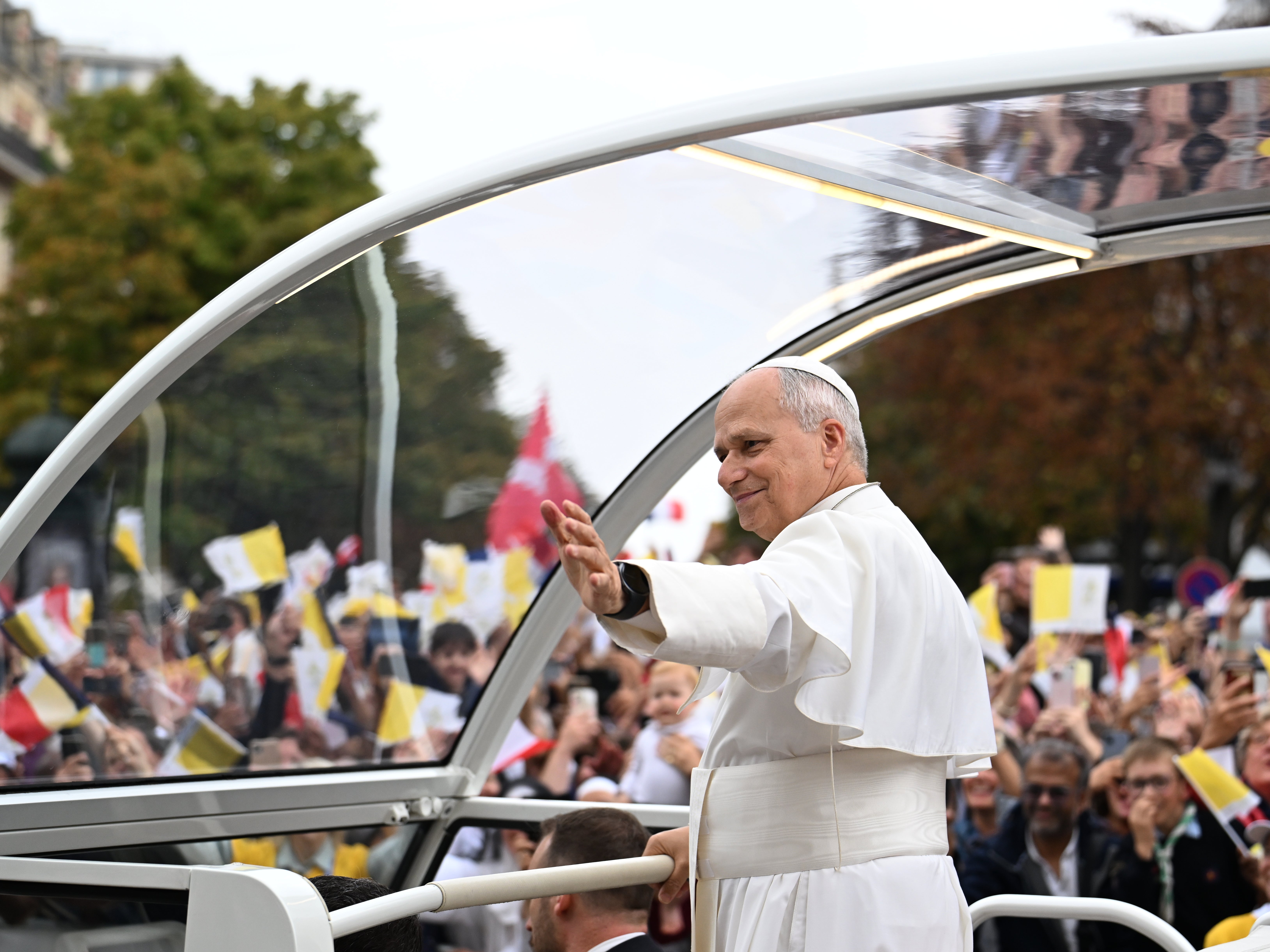 Pope Leo XIV waves to the crowd on the Champs Elysees avenue (AP)