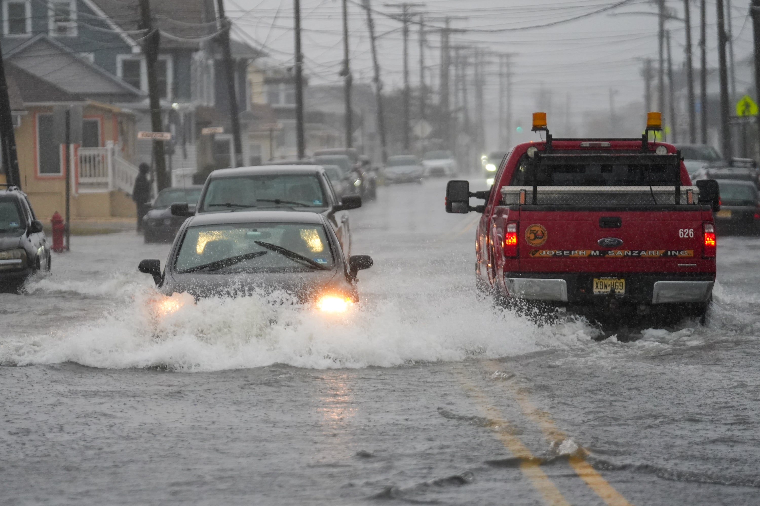 Cars drive through a flooded road in Point Pleasant