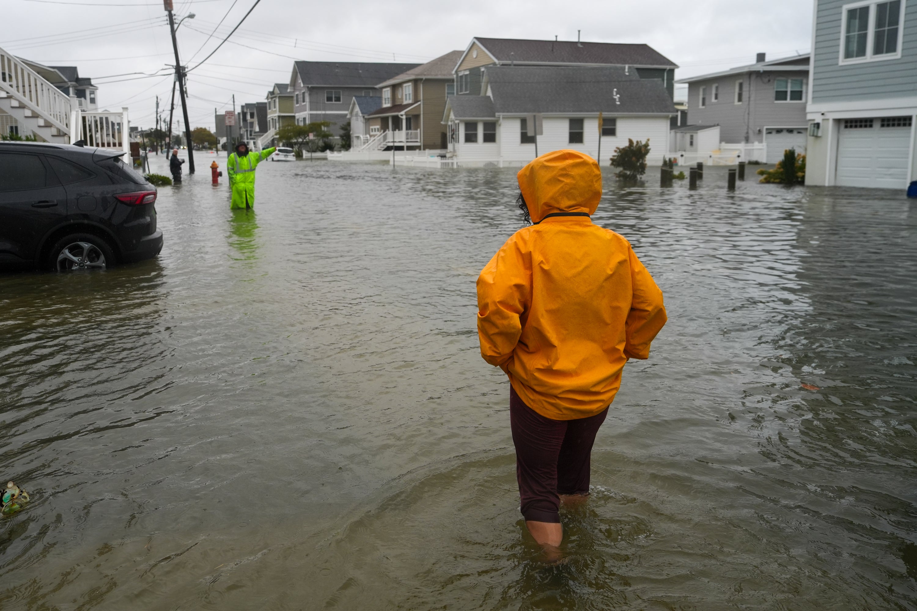 People walk through water on a flooded road during a nor'easter storm where a voluntary evacuation has been issued in the community on September 26, 2026 in Point Pleasant, New Jersey