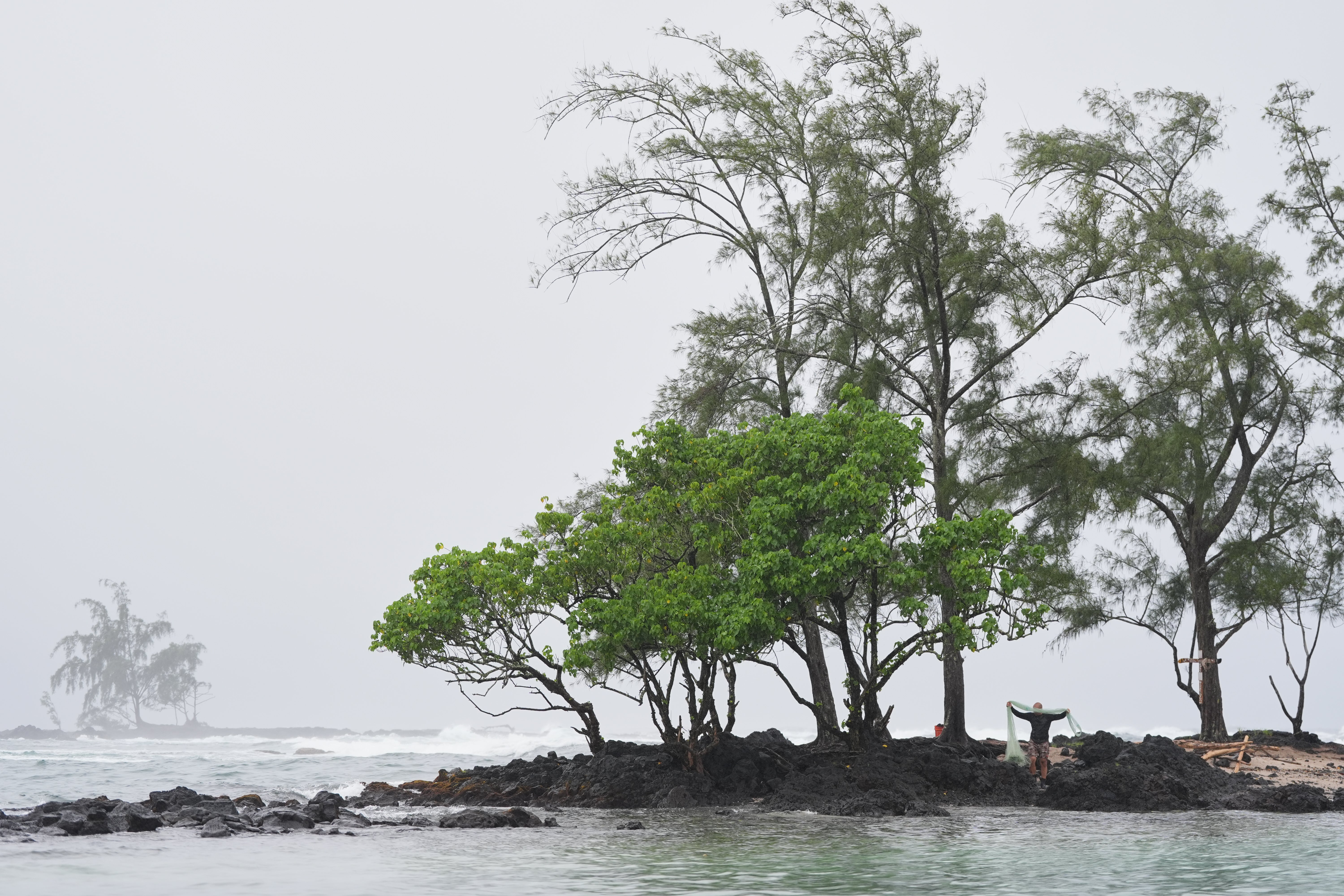Kawika Ige fishes as Hurricane Nolo sits nearby Friday, Sept. 25, 2026, in Hilo
