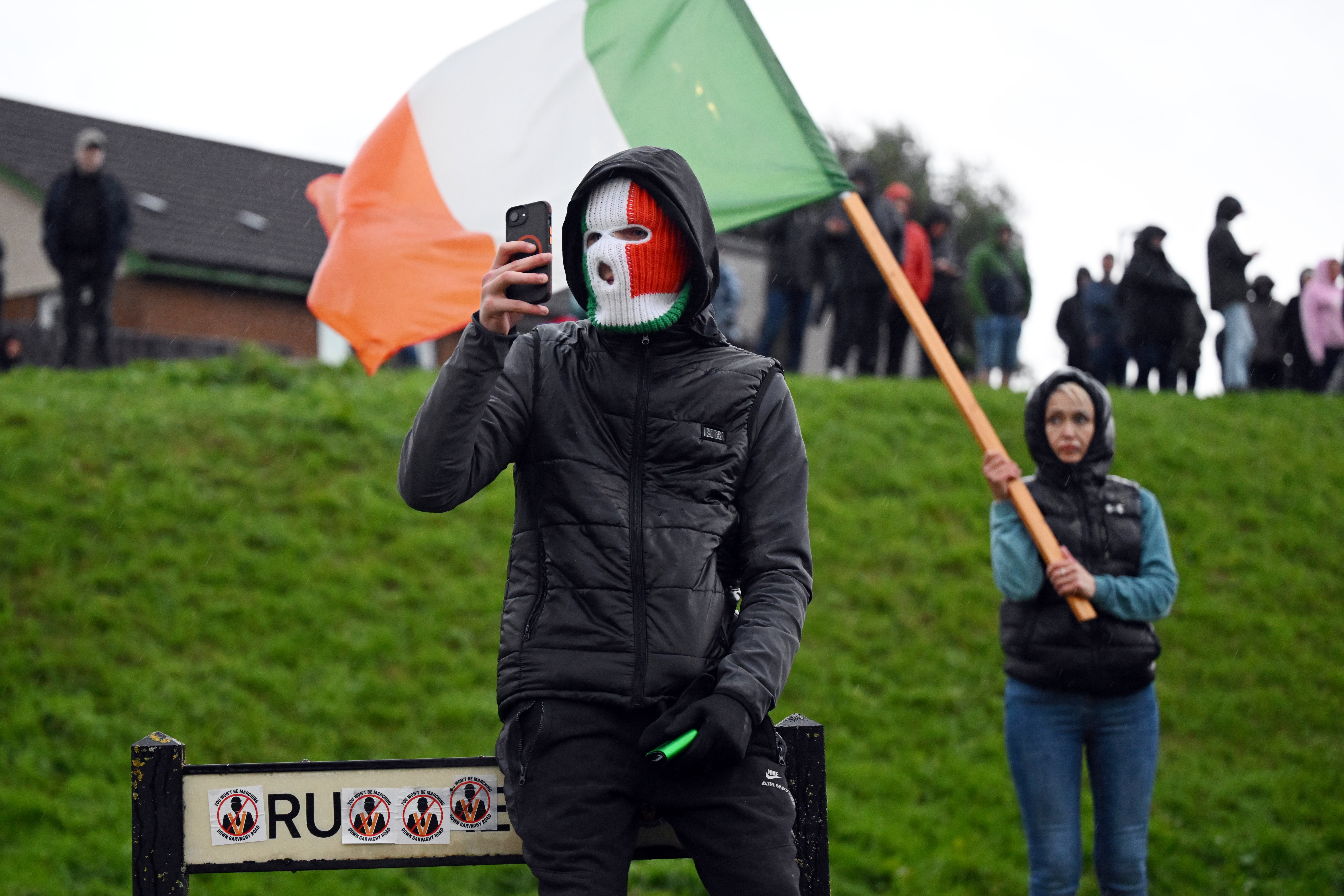 A protester in an Irish flag balaclava