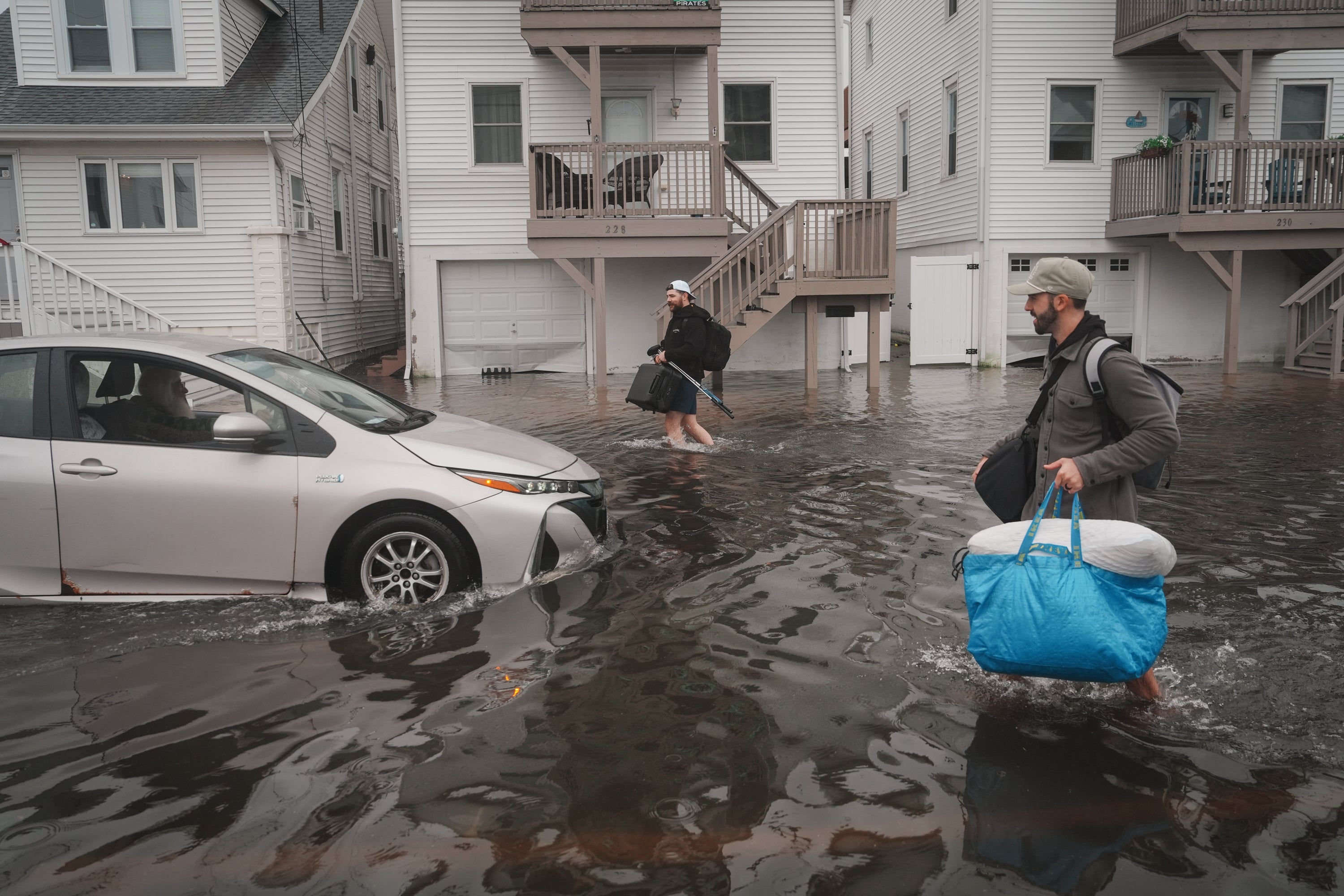 Two people leave a rental home with their belongings after a planned bachelor party was rained-out due to a nor'easter storm, on September 27, 2026 in North Wildwood, New Jersey (Getty)