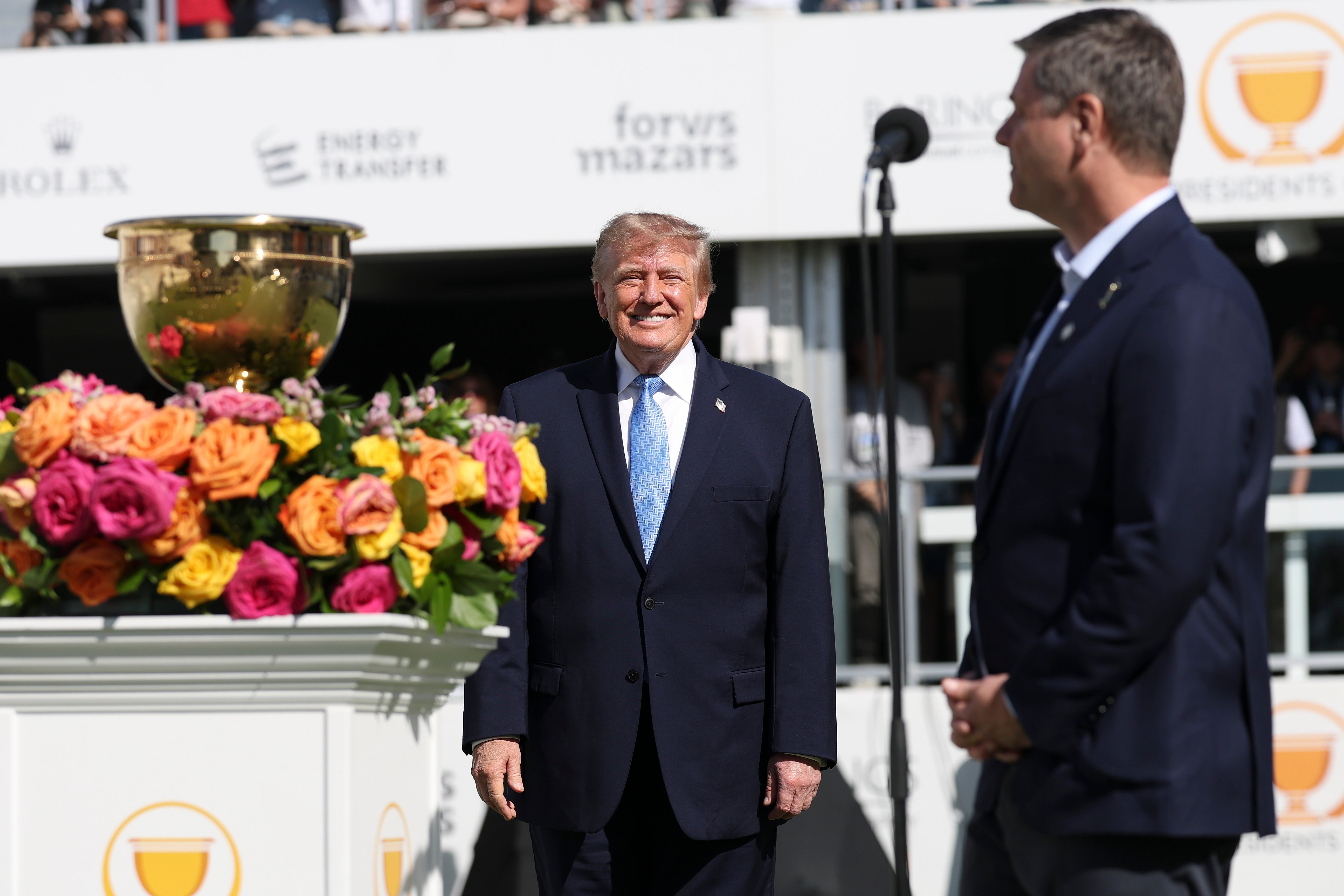 CEO of PGA Tour Brian Rolapp speaks as U.S. President Donald Trump stands on the first tee with the Presidents Cup trophy (Getty)