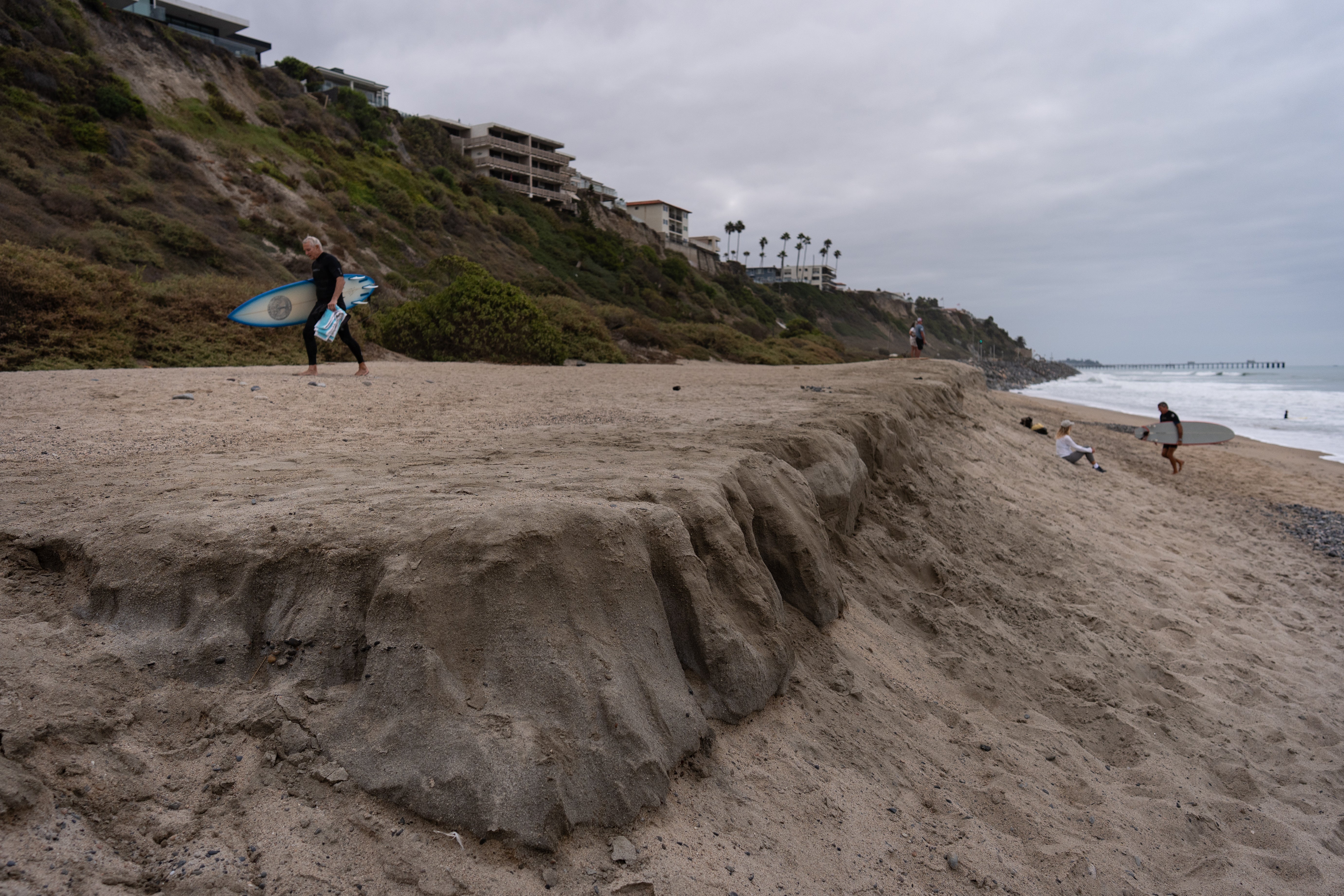 Surfers walk along North Beach in San Clemente, Calif., Friday, Sept. 18, 2026