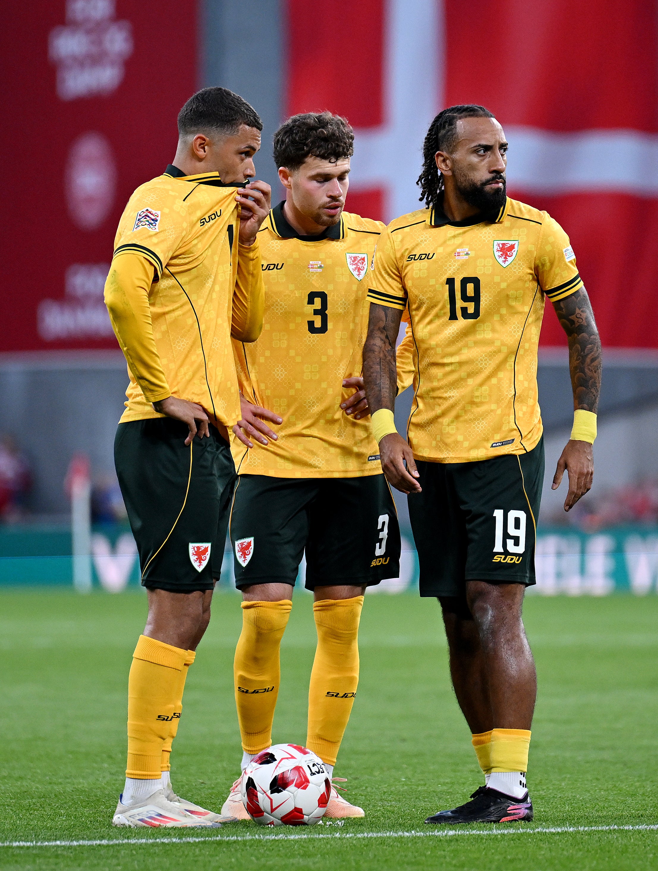 Brennan Johnson, Neco Williams and Sorba Thomas of Wales talk as they stand over the ball