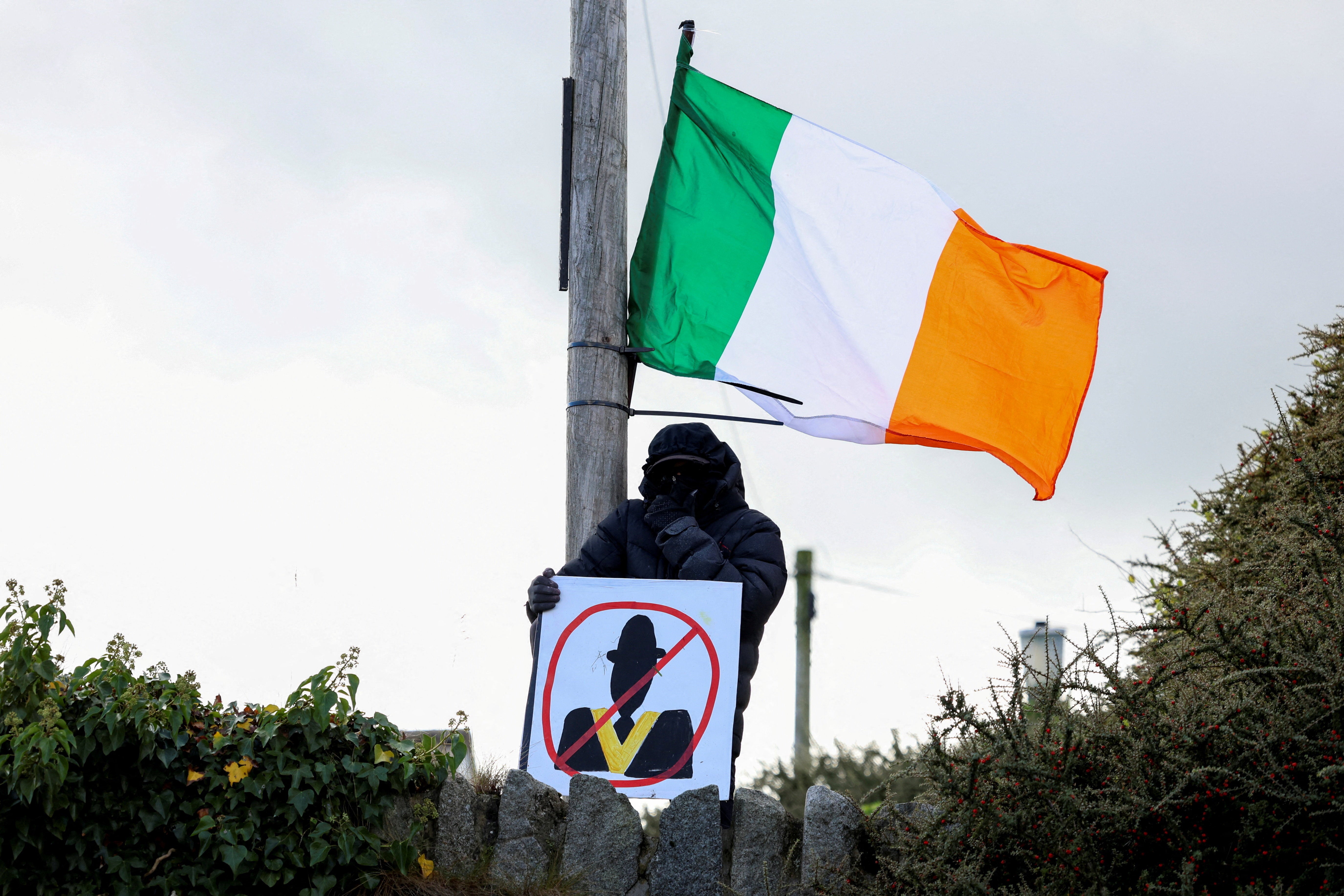 A demonstrator holds a placard as people protest on the Garvaghy Road