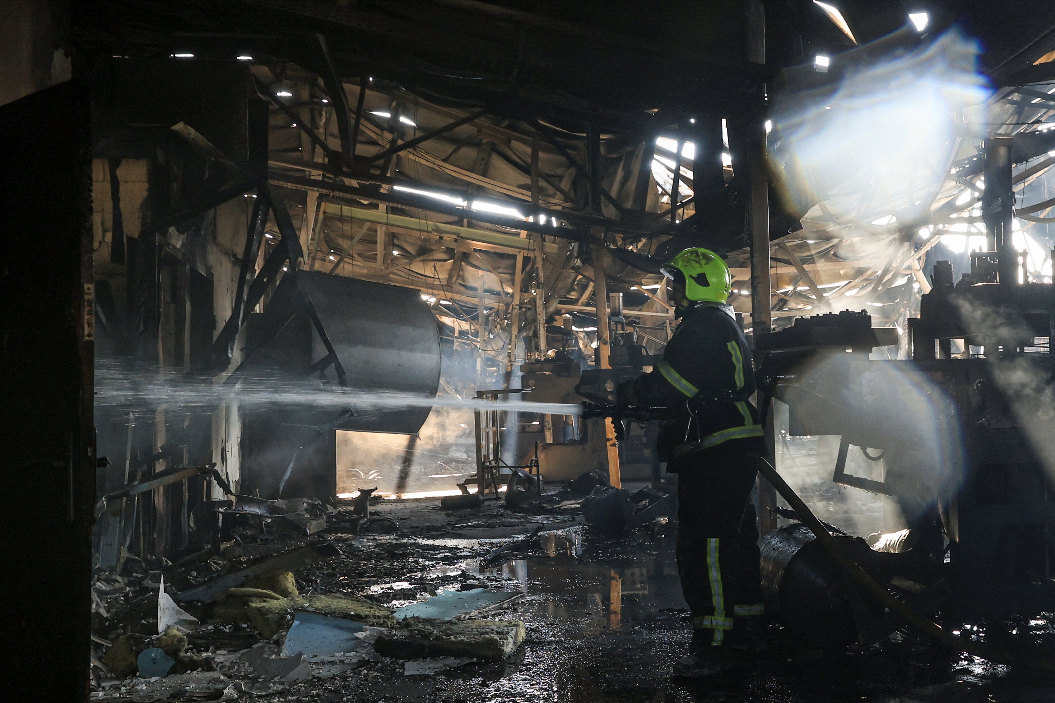 A firefighter works at the site of an enterprise hit by a Russian drone strike, amid Russia's attack on Ukraine, on the outskirts of Odesa