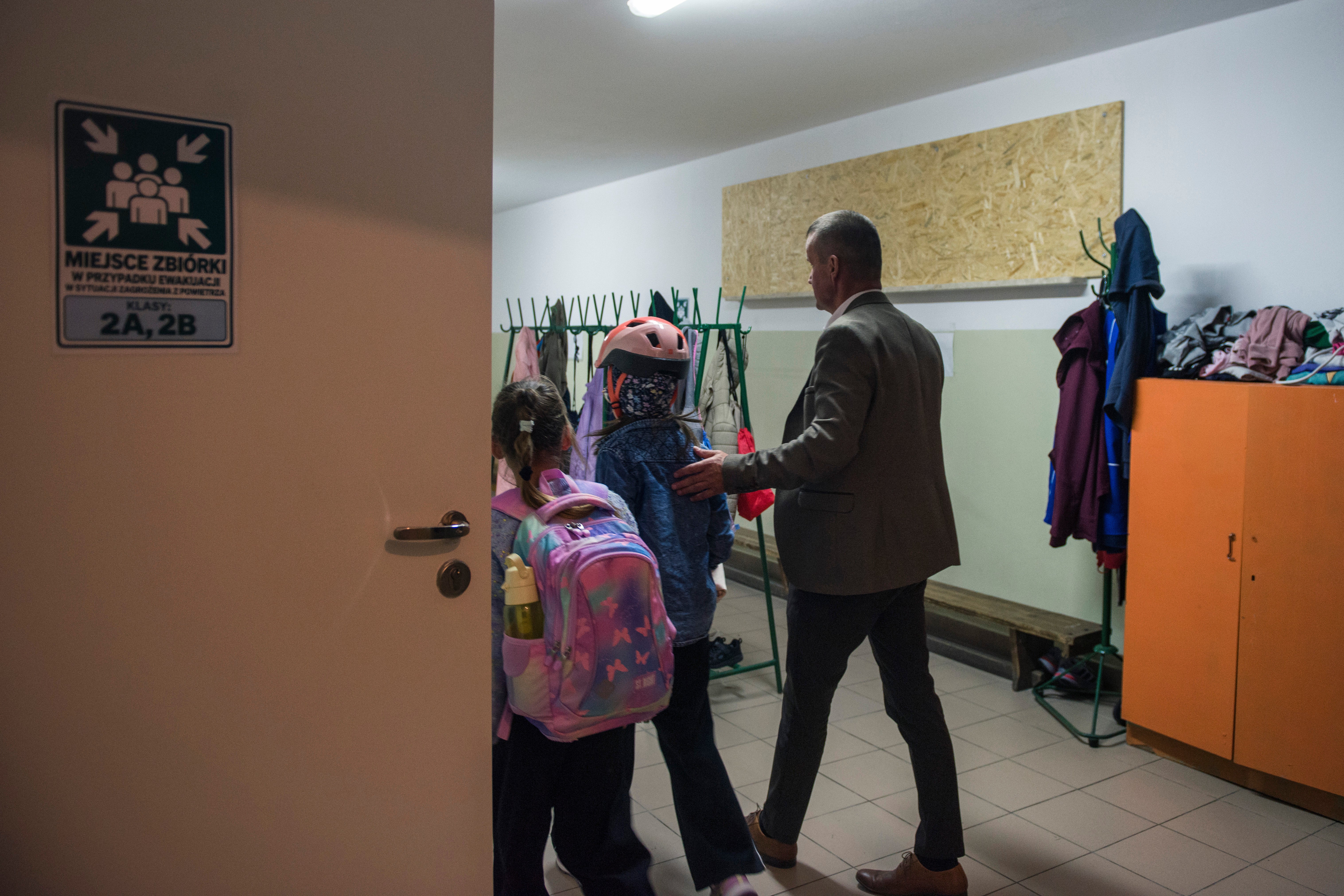 Jarosław Wojcik, the school principal guides children into a school cloakroom, which has been converted into a makeshift bomb shelter, in Dorohusk, Poland, on Sept. 24, 2026