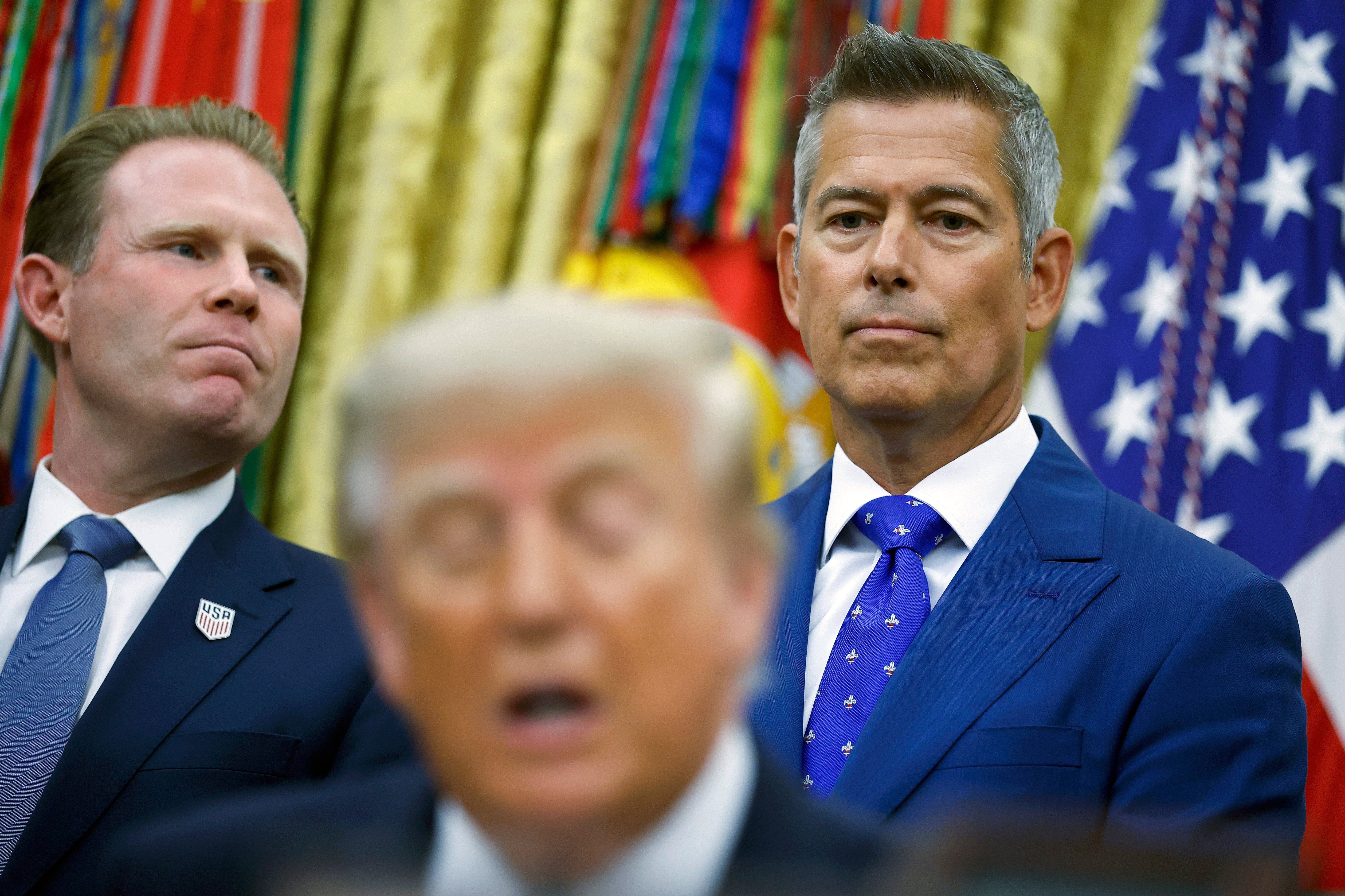 Executive Director for the White House Task Force on the FIFA World Cup 2026 Andrew Giuliani (L) and U.S. Transportation Secretary Sean Duffy attend a meeting with U.S. President Donald Trump and U.S. travel executives in the Oval Office