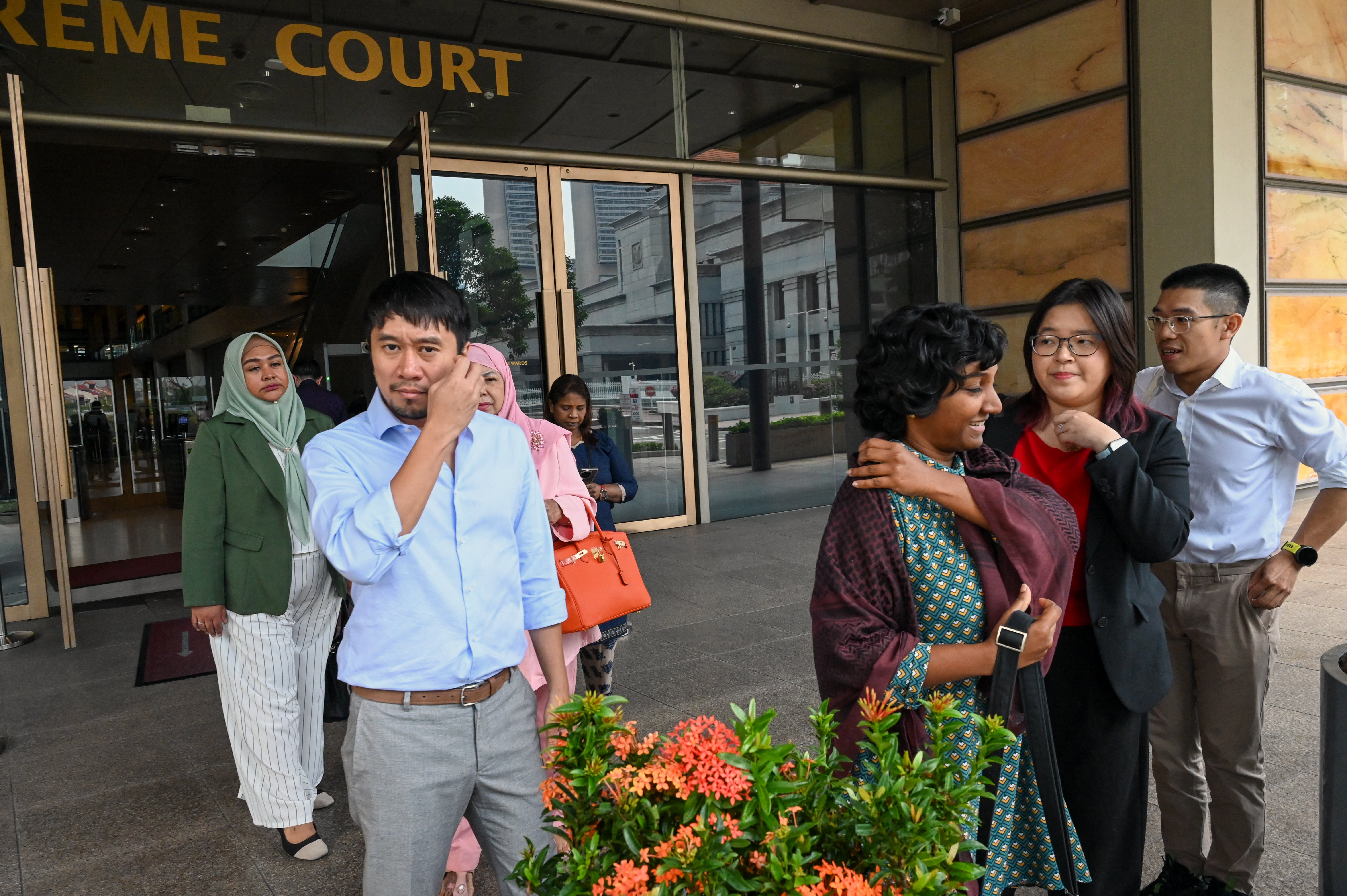 Singaporean activists Kirsten Han (2nd R), Kokila Annamalai (3rd R) and Jolovan Wham (2nd L) leave the Supreme Court in Singapore on 3 December, 2025 (AFP/Getty)