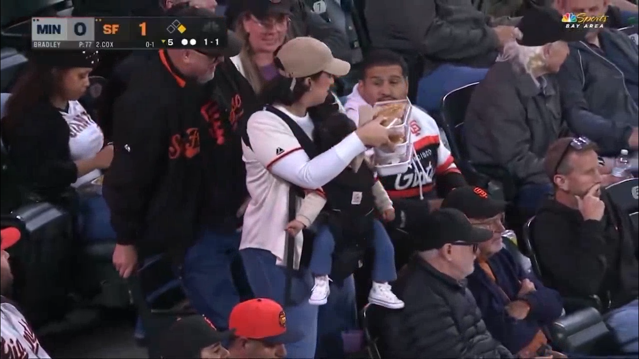 Multi-tasking mom seen juggling baby and snacks at Giants game defends husband after internet attacks