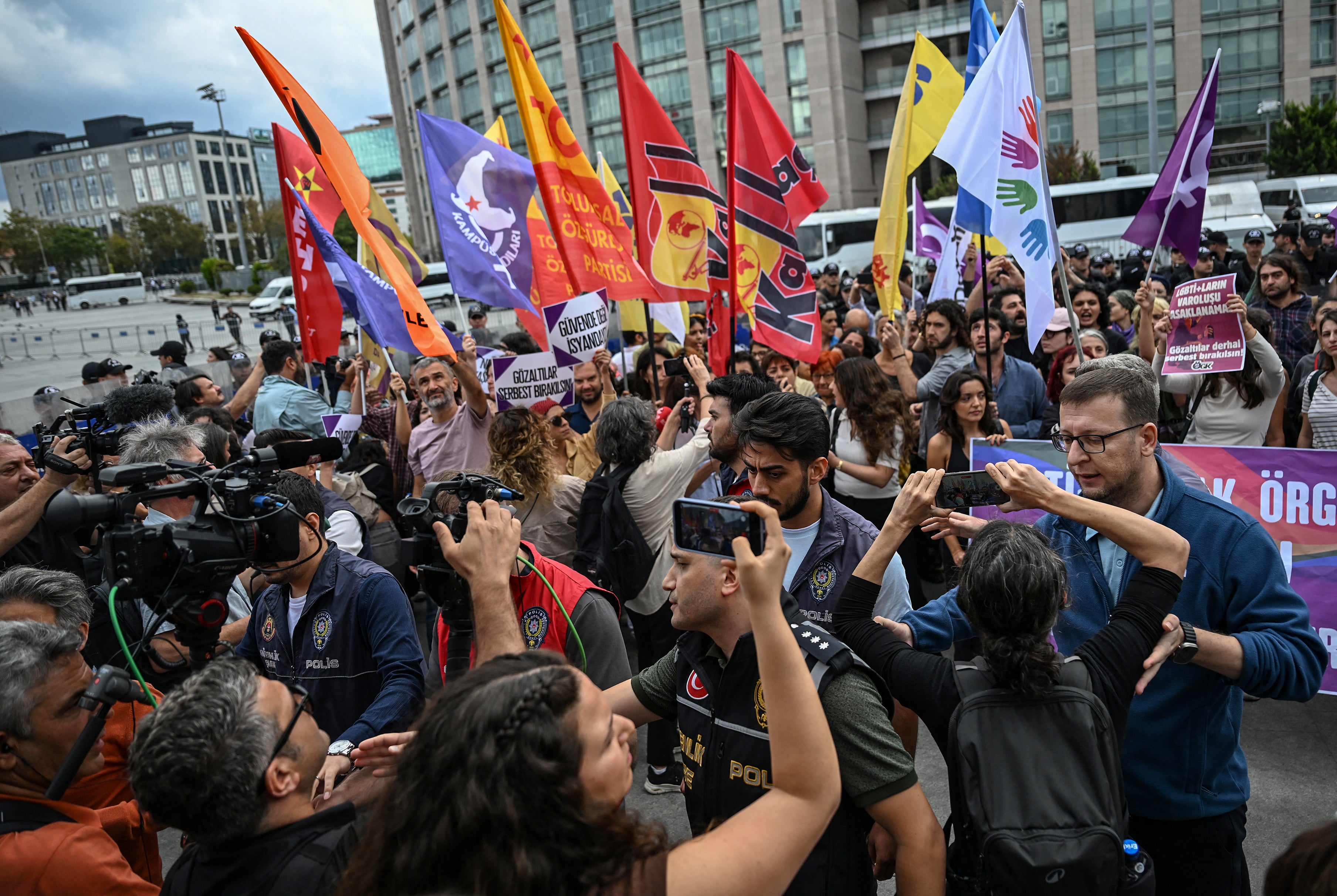 Turkish police push back journalists away from people demonstrating outside Istanbul's courthouse to protest over the arrest and growing targeting of LGBTQ+ activists