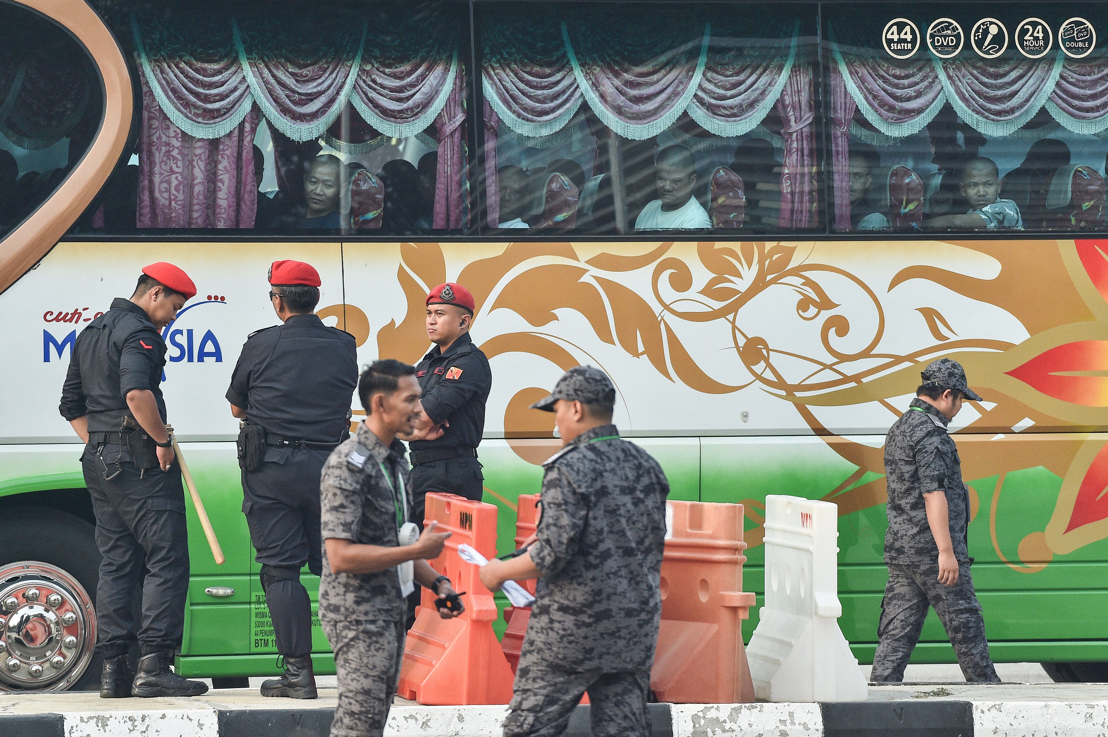 A bus carrying Myanmarese nationals being repatriated from Malaysia heads towards the naval base in Lumut on the outskirts of Kuala Lumpur (AFP/Getty)