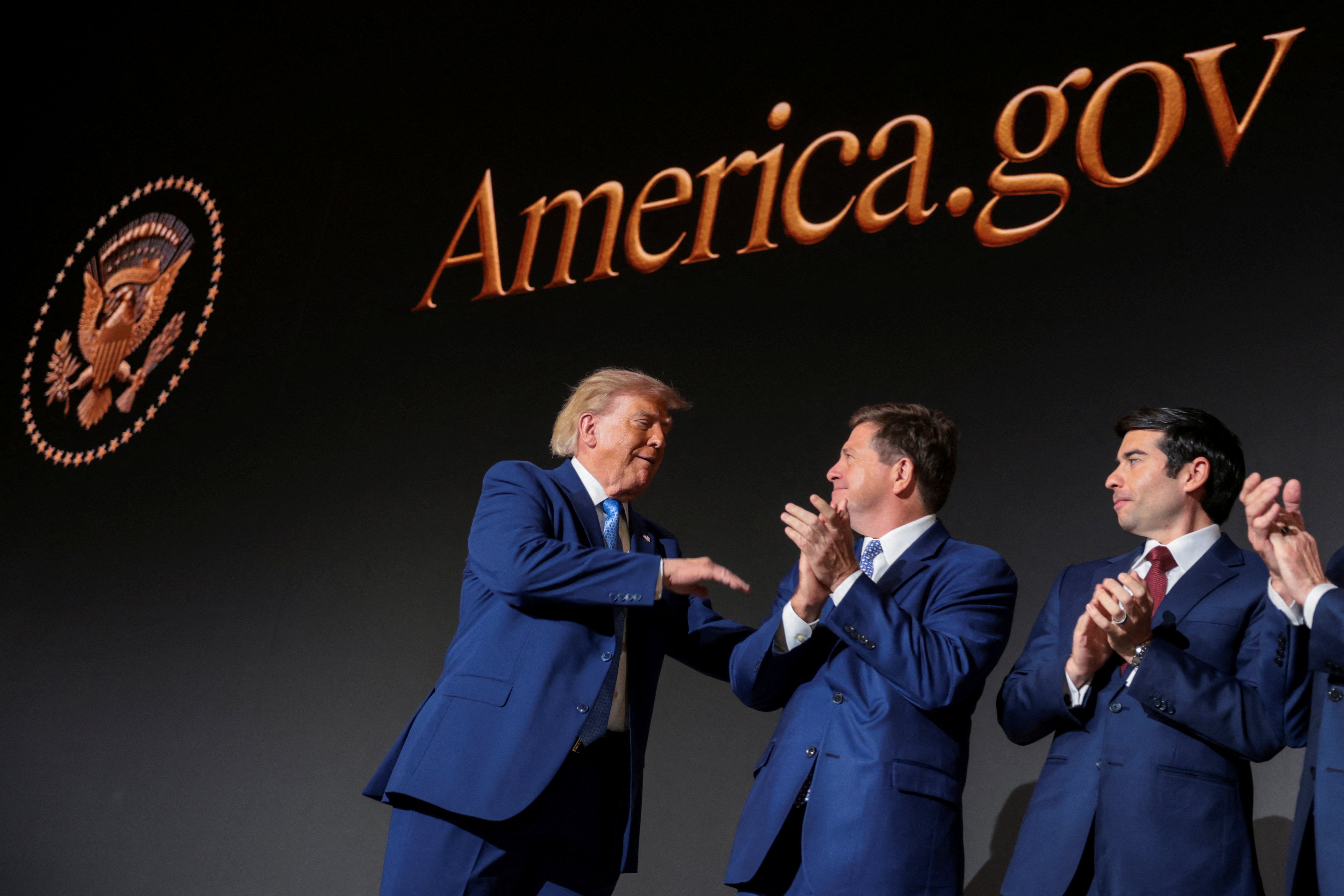 Donald Trump congratulates members of the National Design Studio at the launch of America.gov