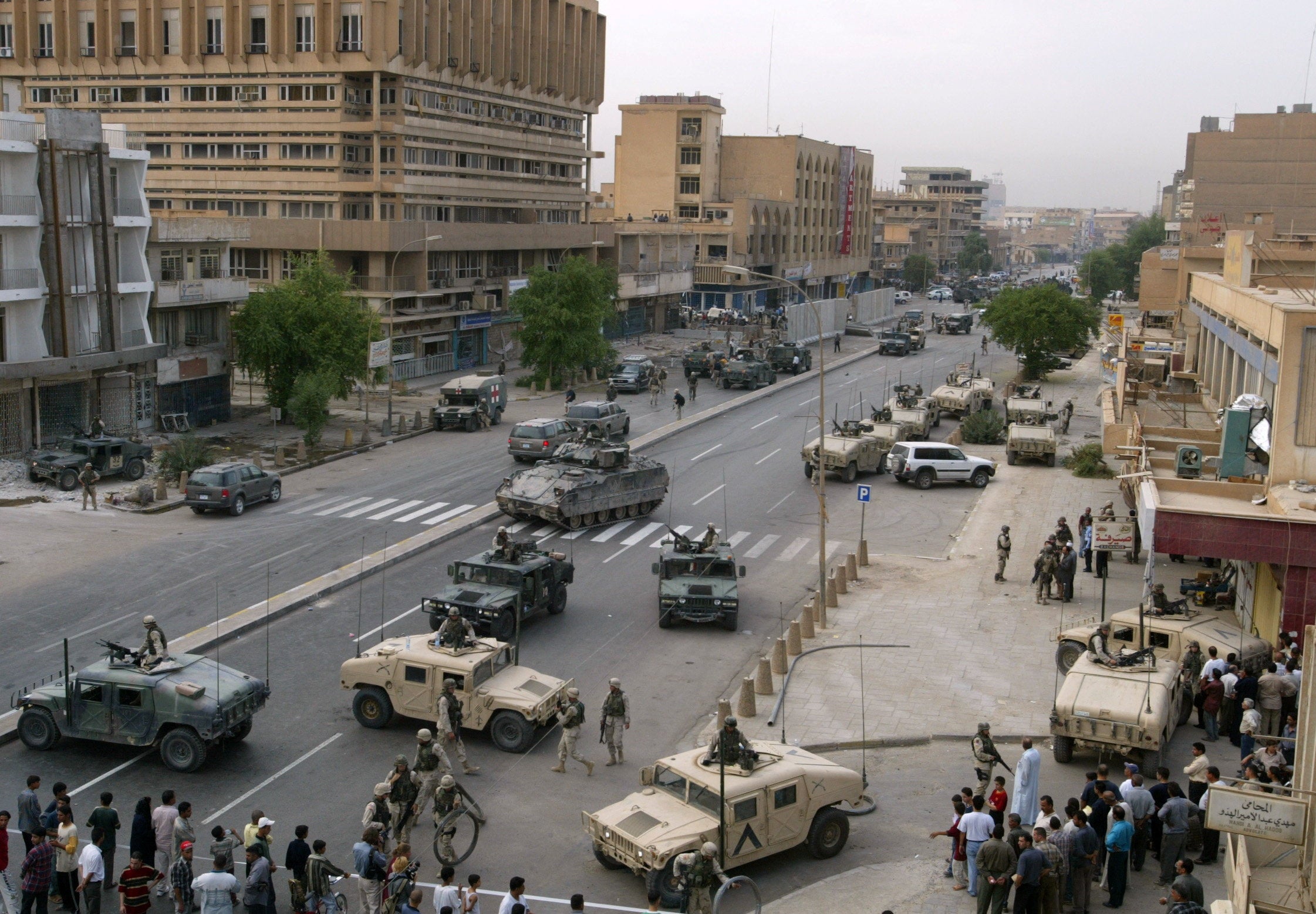Iraqi police and US Army soldiers at the scene after a car exploded on a street in Baghdad, Iraq, October 12, 2003