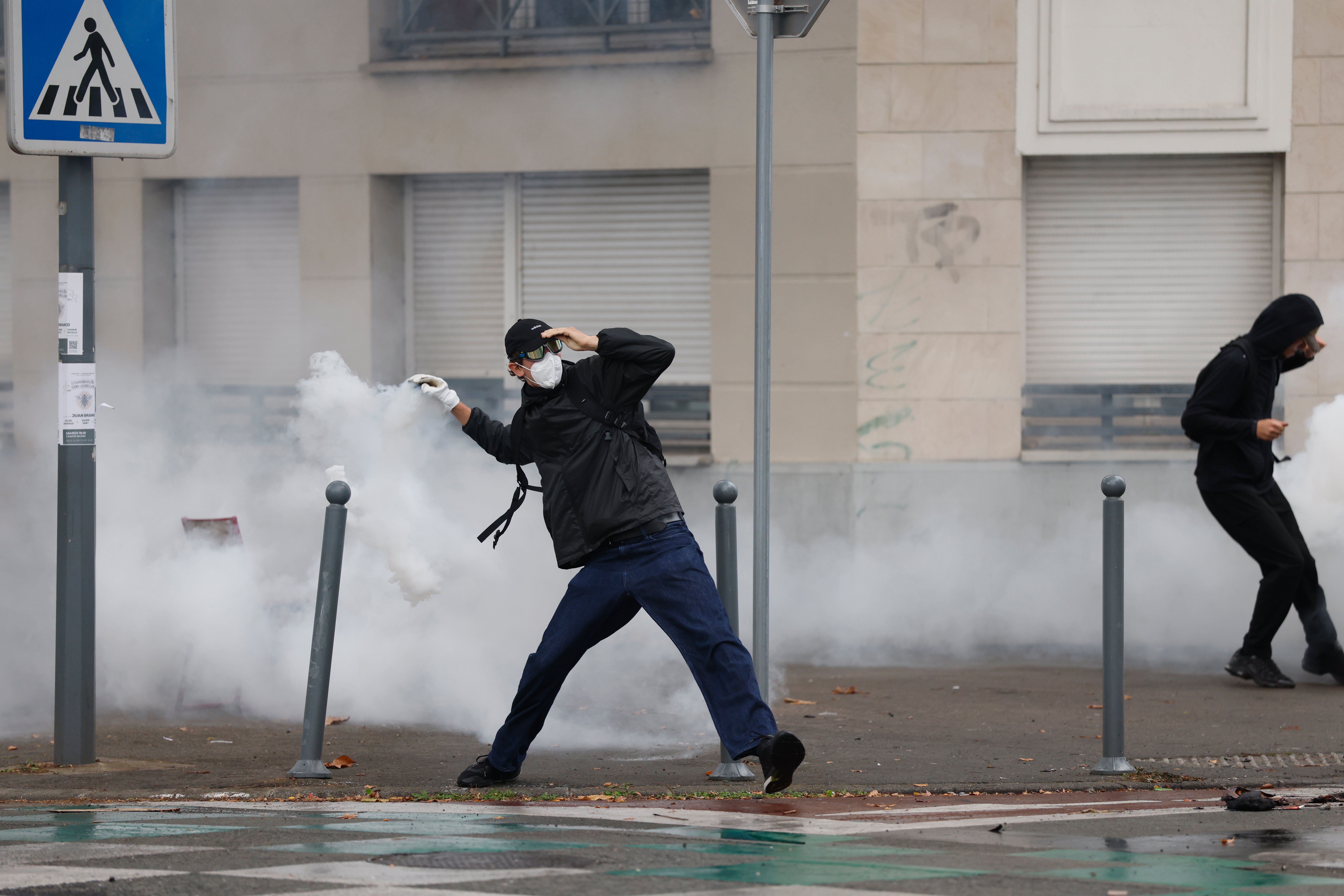 A high school student throws a tear gas canister as he protests to demand more resources for schools, in Lille, France, Wednesday, Sept. 30, 2026. (AP Photo/Jean-Francois Badias) (AP)