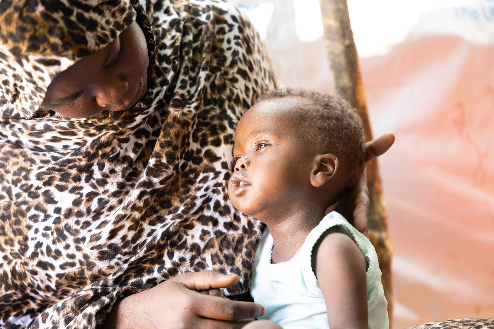 Maymauna, 27, cradles her young son, Mayamat, 2, in the Goudrane Refugee Camp in Chad. Mayamat lost most of his motor neurone skills during the siege of El Fasher