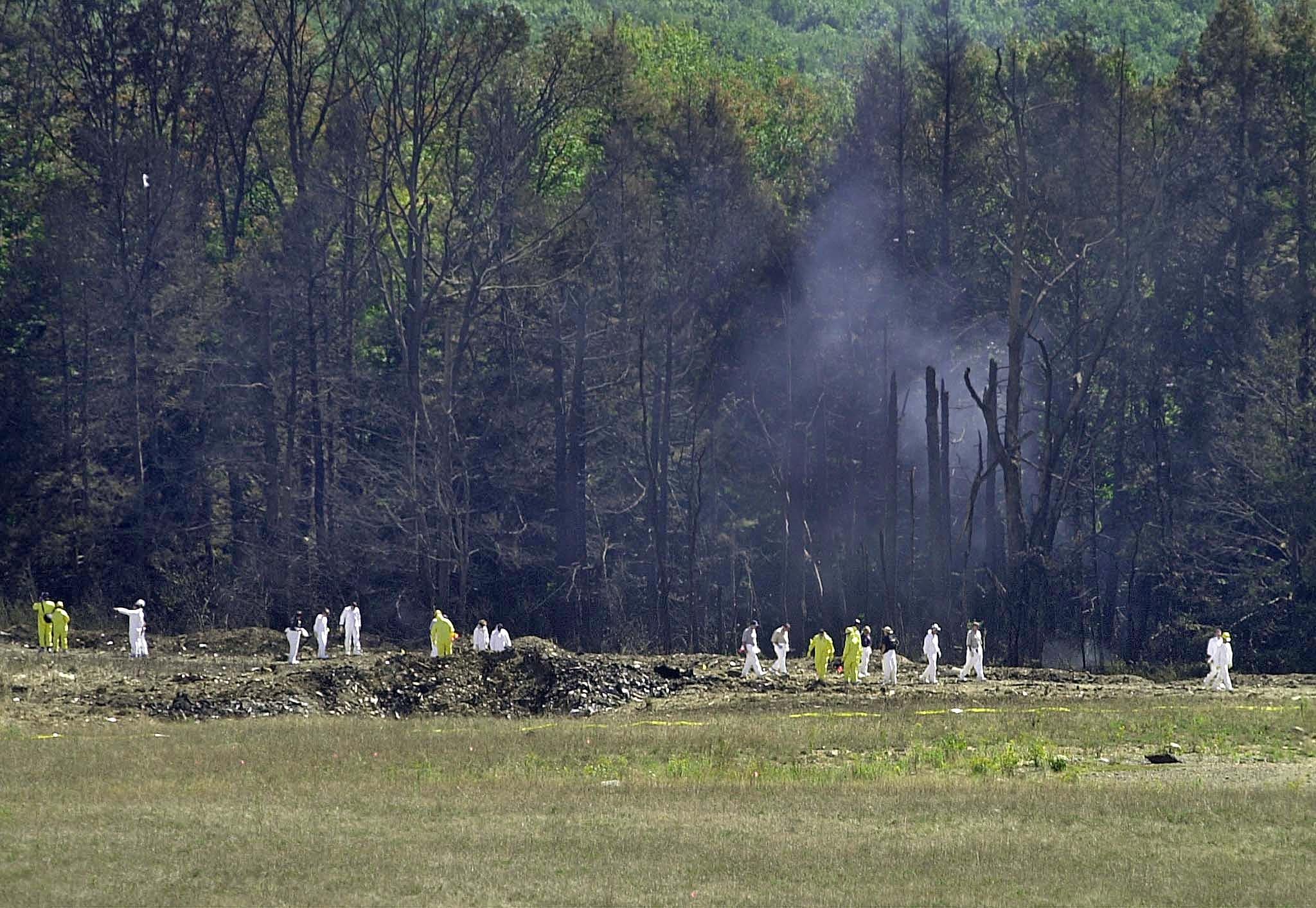 Investigative personnel search the crash site of United Airlines Flight 93 looking for debris and evidence, including the plane's flight recorder, 12 September 2001 in Shanksville, Pennsylvania.