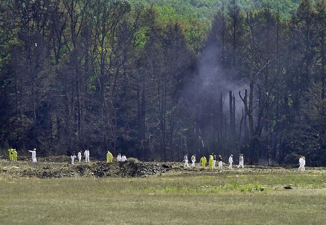 Investigative personnel search the crash site of United Airlines Flight 93 looking for debris and evidence, including the plane's flight recorder, 12 September 2001 in Shanksville, Pennsylvania.