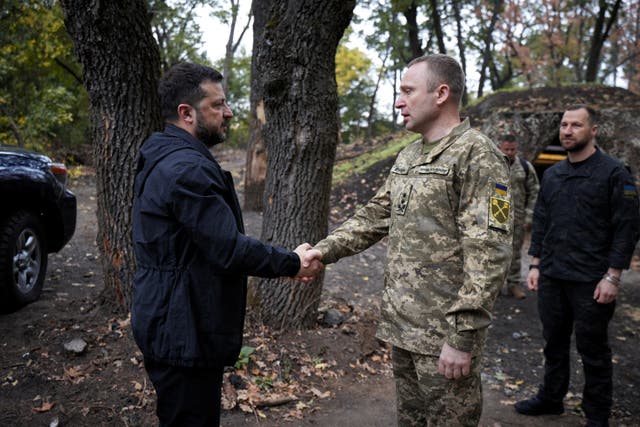 President Zelensky and the commander of the Ukraine's armed forces shake hands as they visit service members of the 66th Separate Mechanised Brigade