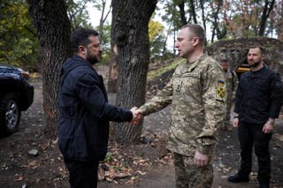 President Zelensky and the commander of the Ukraine's armed forces shake hands as they visit service members of the 66th Separate Mechanised Brigade