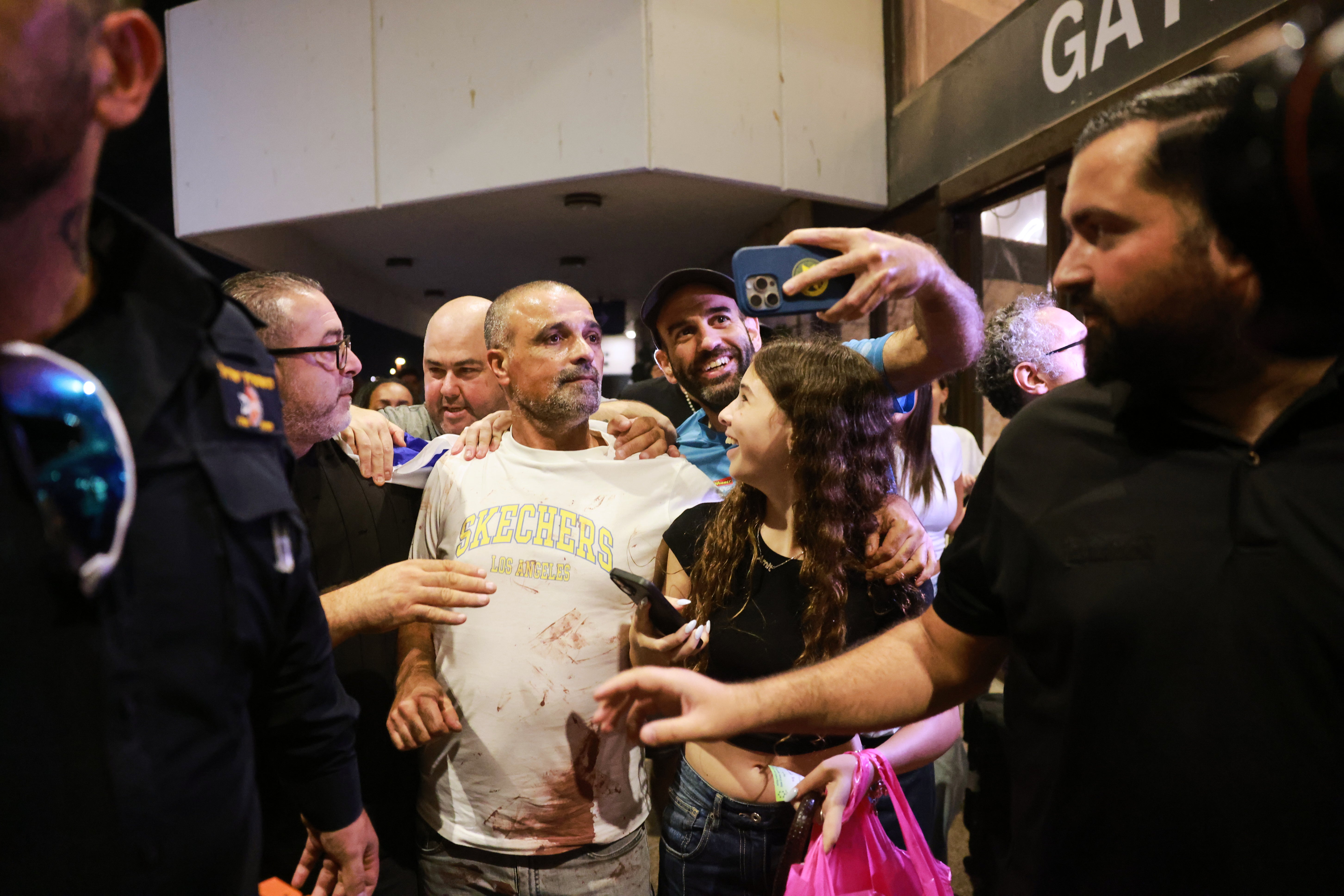 Israeli passenger Yaniv Hayoun, with blood stains on his shirt, who was aboard a Flydubai aircraft that made an emergency landing in Saudi Arabia, is welcomed at the arrivals gate at Ben Gurion International Airport near Tel Aviv (AP)