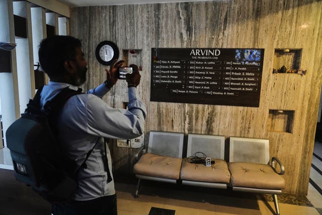 News media personnel film in the building where relatives of Smit Machchhar, an Indian pilot for Flydubai, previously lived in Mumbai, India, Thursday, Oct. 1, 2026. (AP Photo/Rafiq Maqbool)