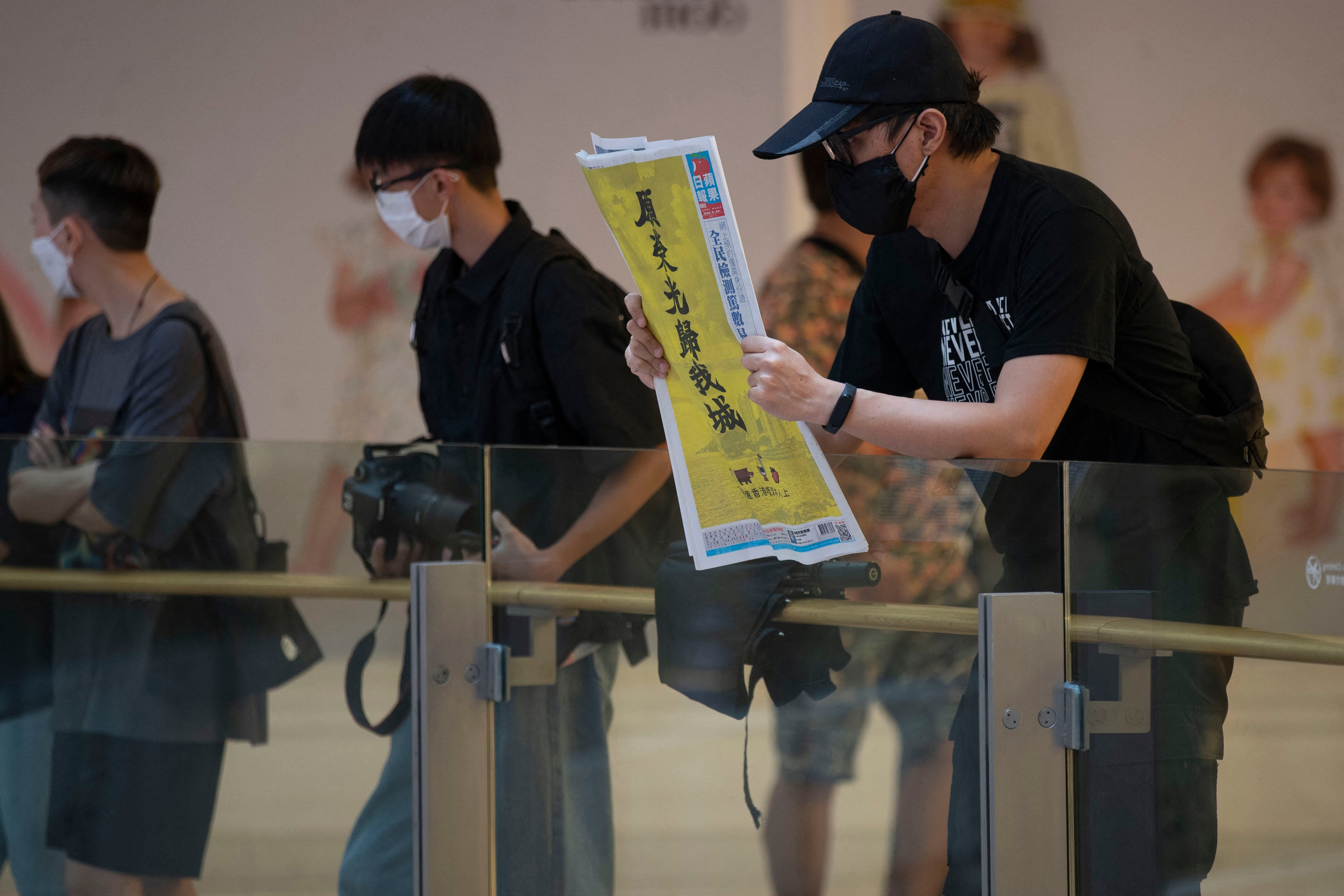 A man holds a copy of Apple Daily during a demonstration on the eve of the first anniversary of the Prince Edward MTR station incident in Hong Kong on 30 August 2020 (AFP/Getty)