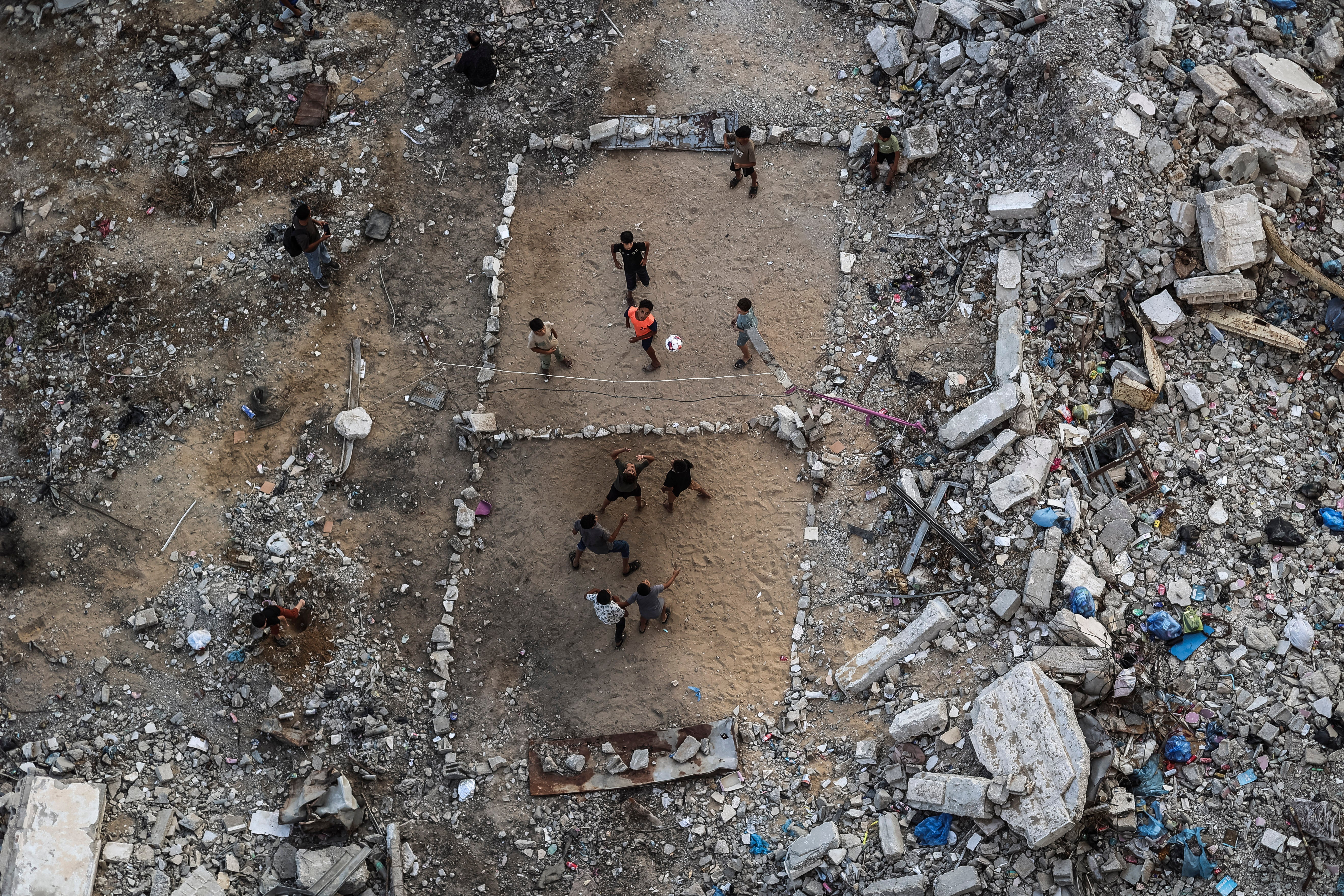 Palestinian children built a makeshift volleyball court made of rubble in Gaze City